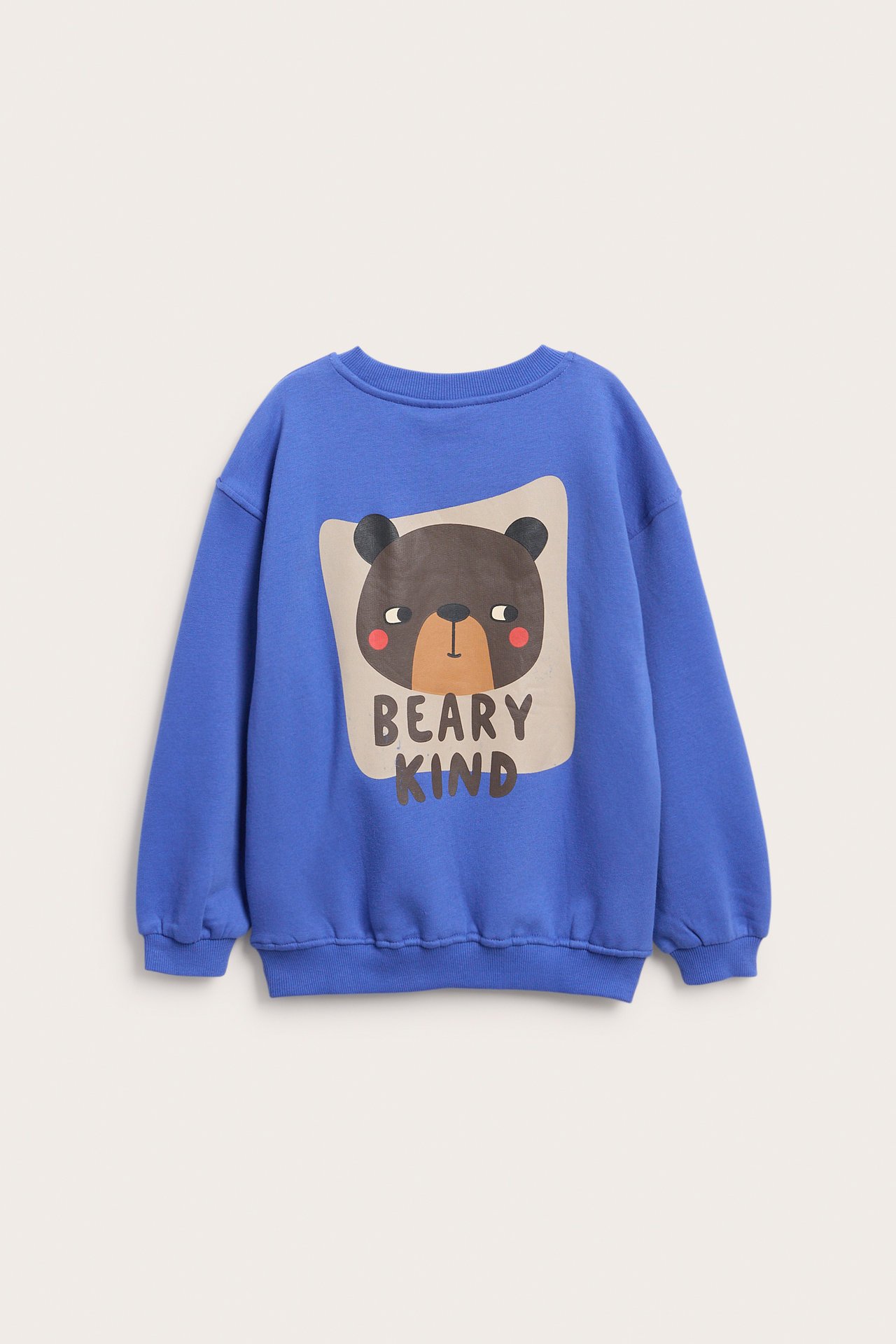 Edestä kuvattu lasten sininen collegepaita, jossa karhukuvio ja teksti 'BEARY KIND'.