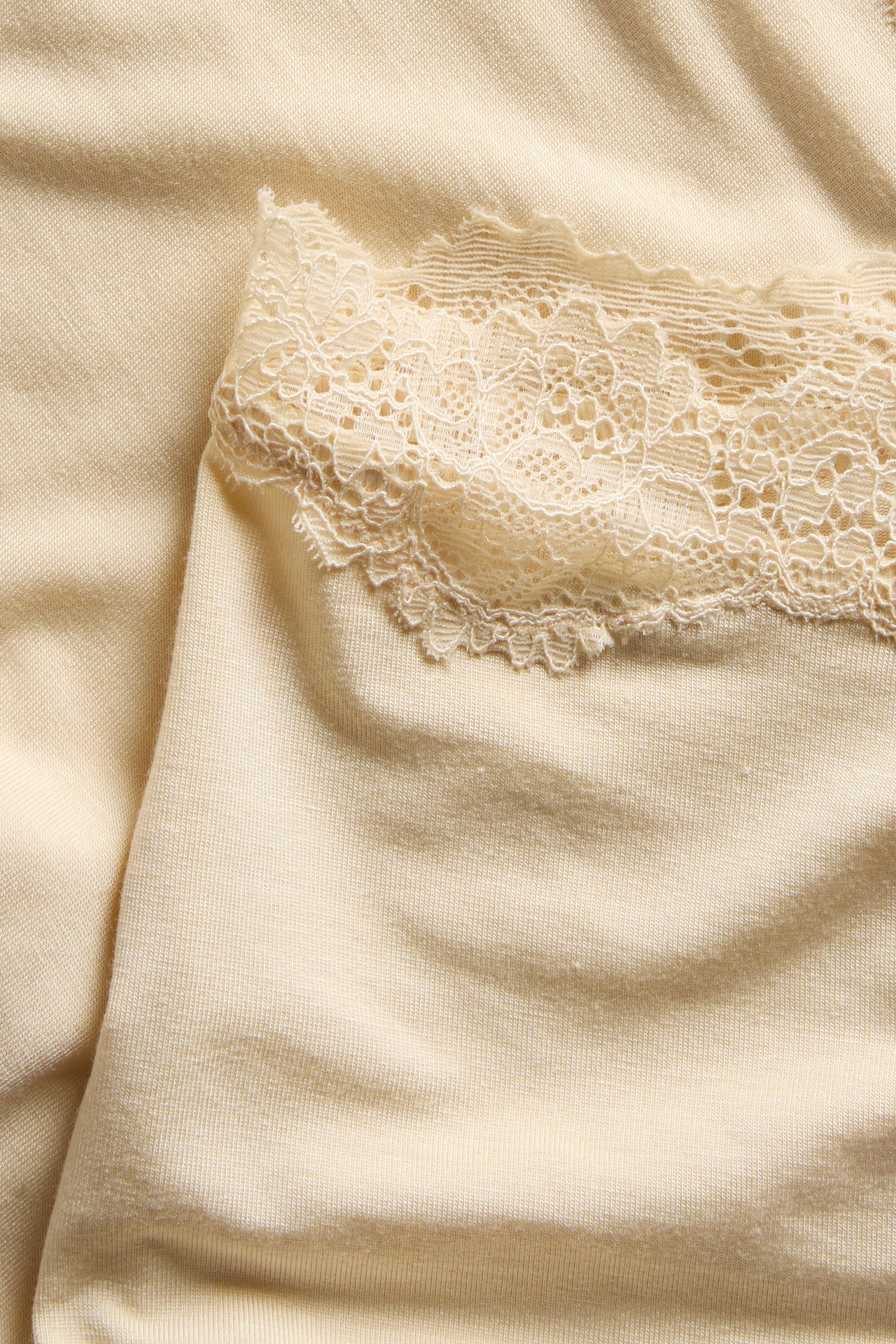 Nærbilde av beige modal boxertruse med blondekantet midje.