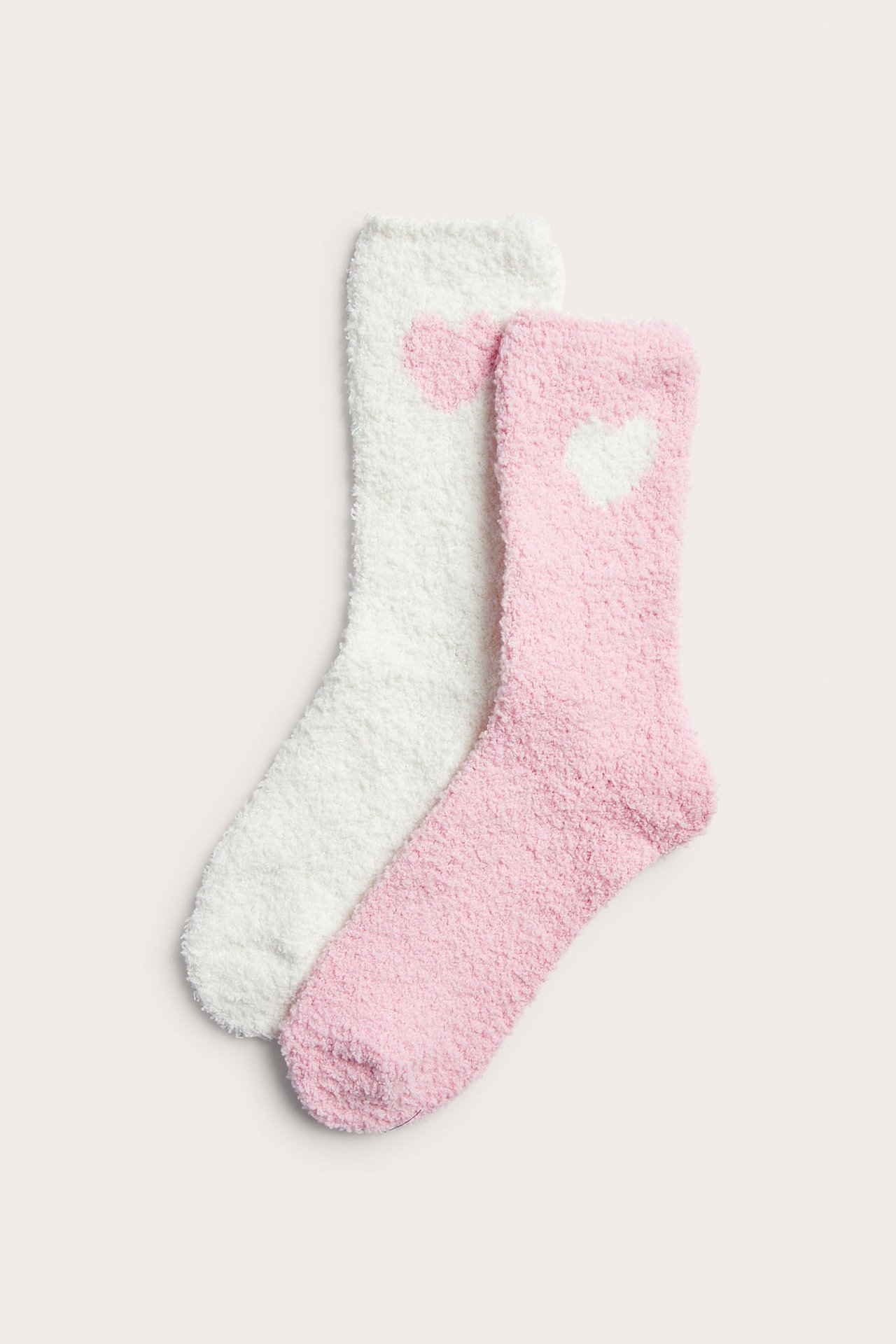 Forfra: to lodne sokker, en rosa med hvitt hjerte og en hvit med rosa hjerte.