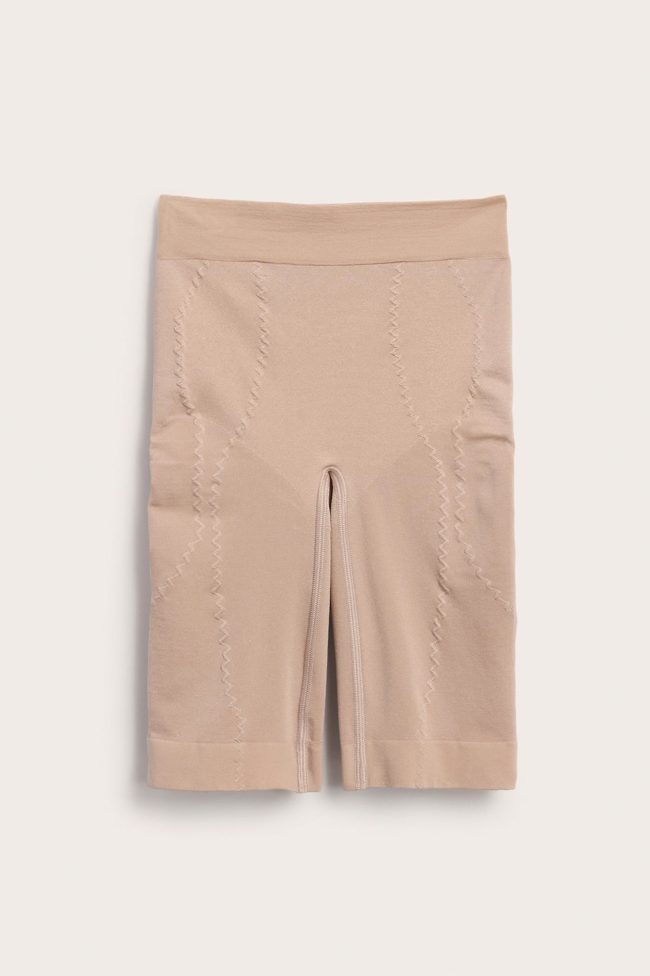 Frontbilde av beige sømløse shapingshorts med høy støtte og sikksakksømmer for forming.