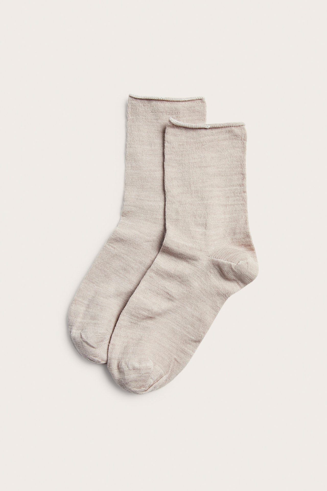 To lys beige strikkede sokker, flat lay.
