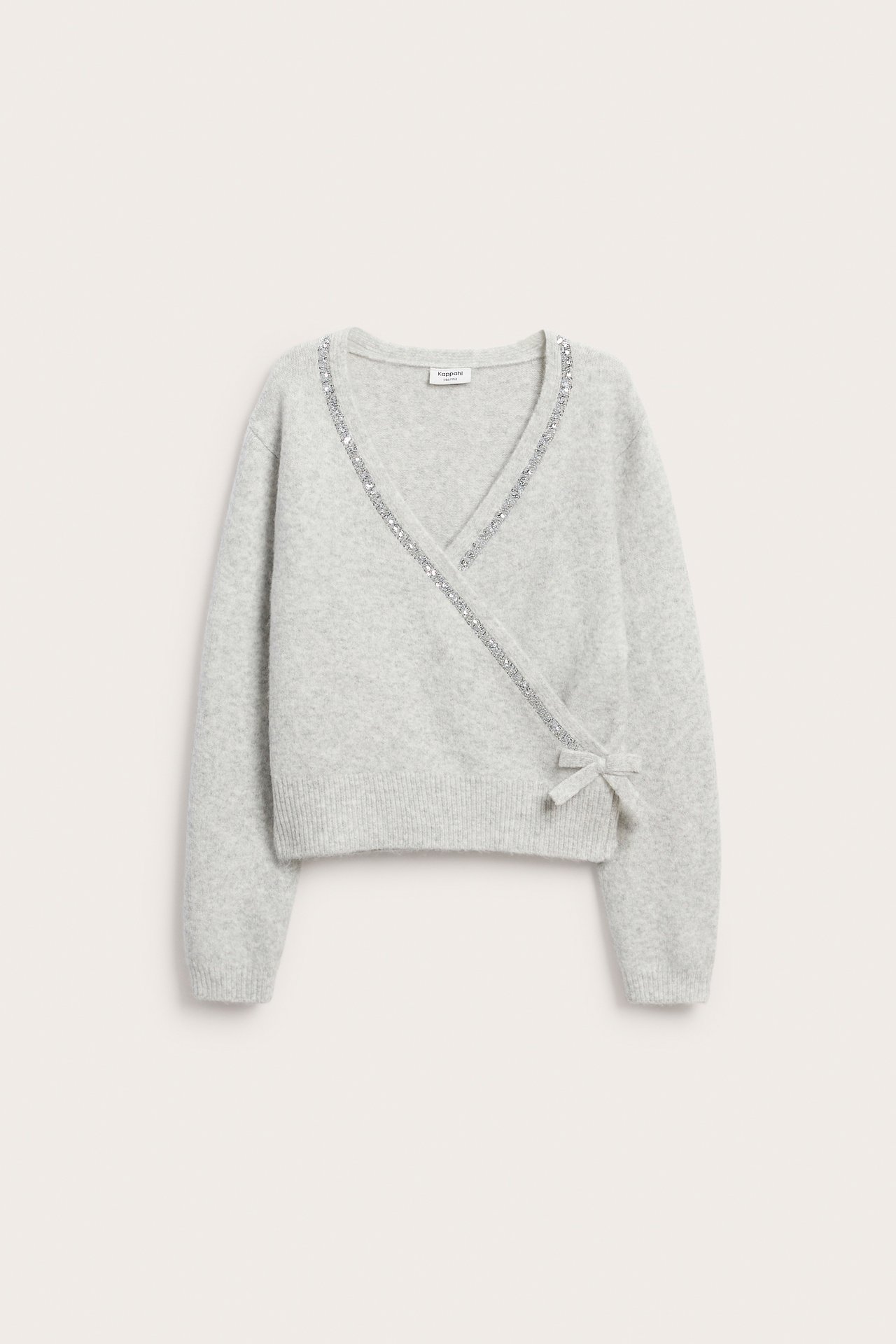 Front, lys grå strikket omslagscardigan med strass-kant og knyting i siden.