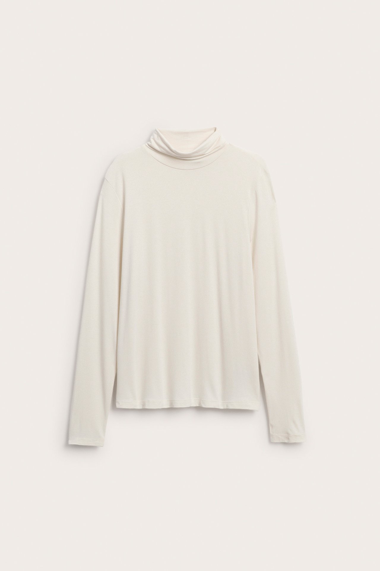 Framifrån, ljusbeige långärmad polotröja.