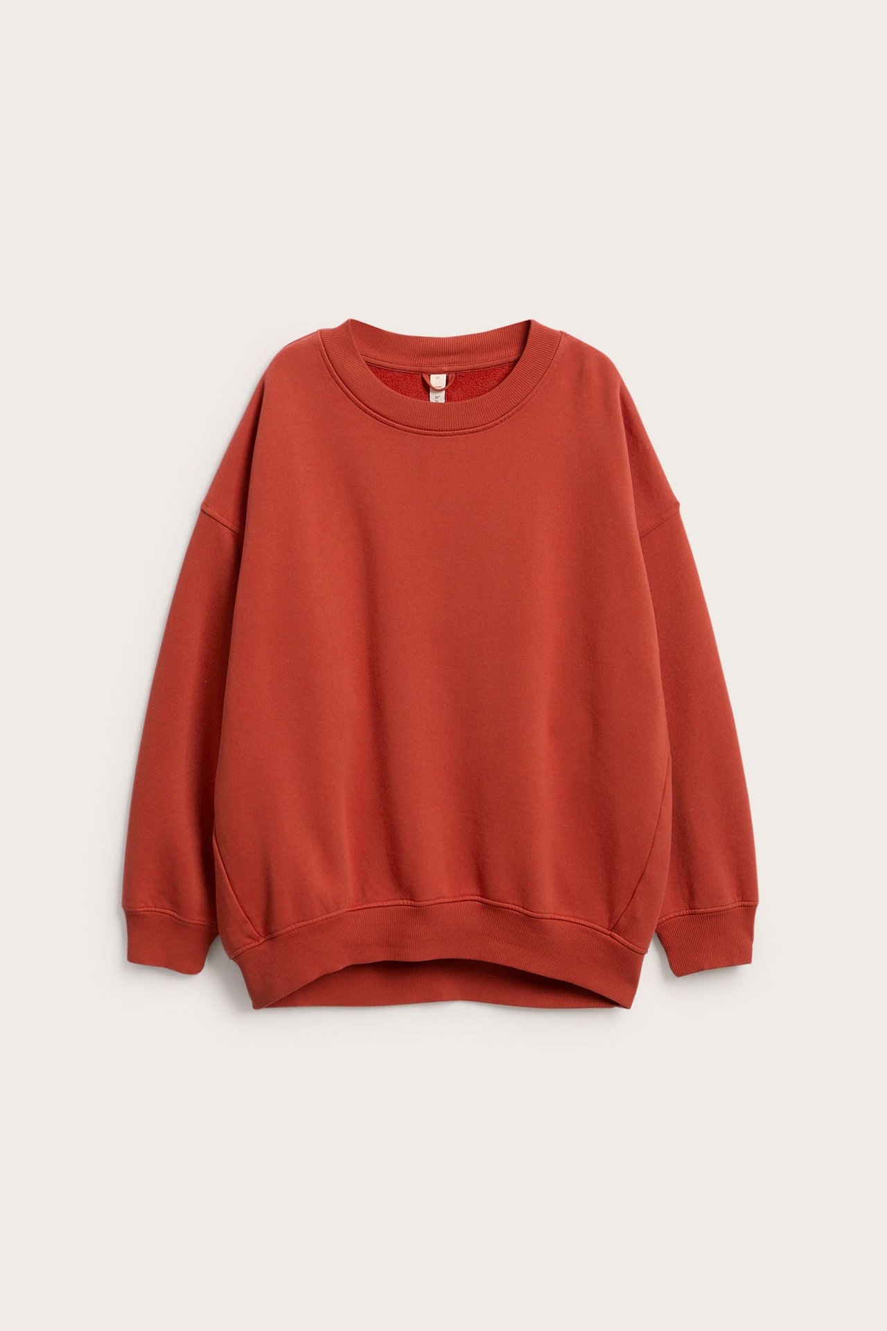 Frontvisning av en rød oversized sweatshirt i bomullsblanding med vasket look.