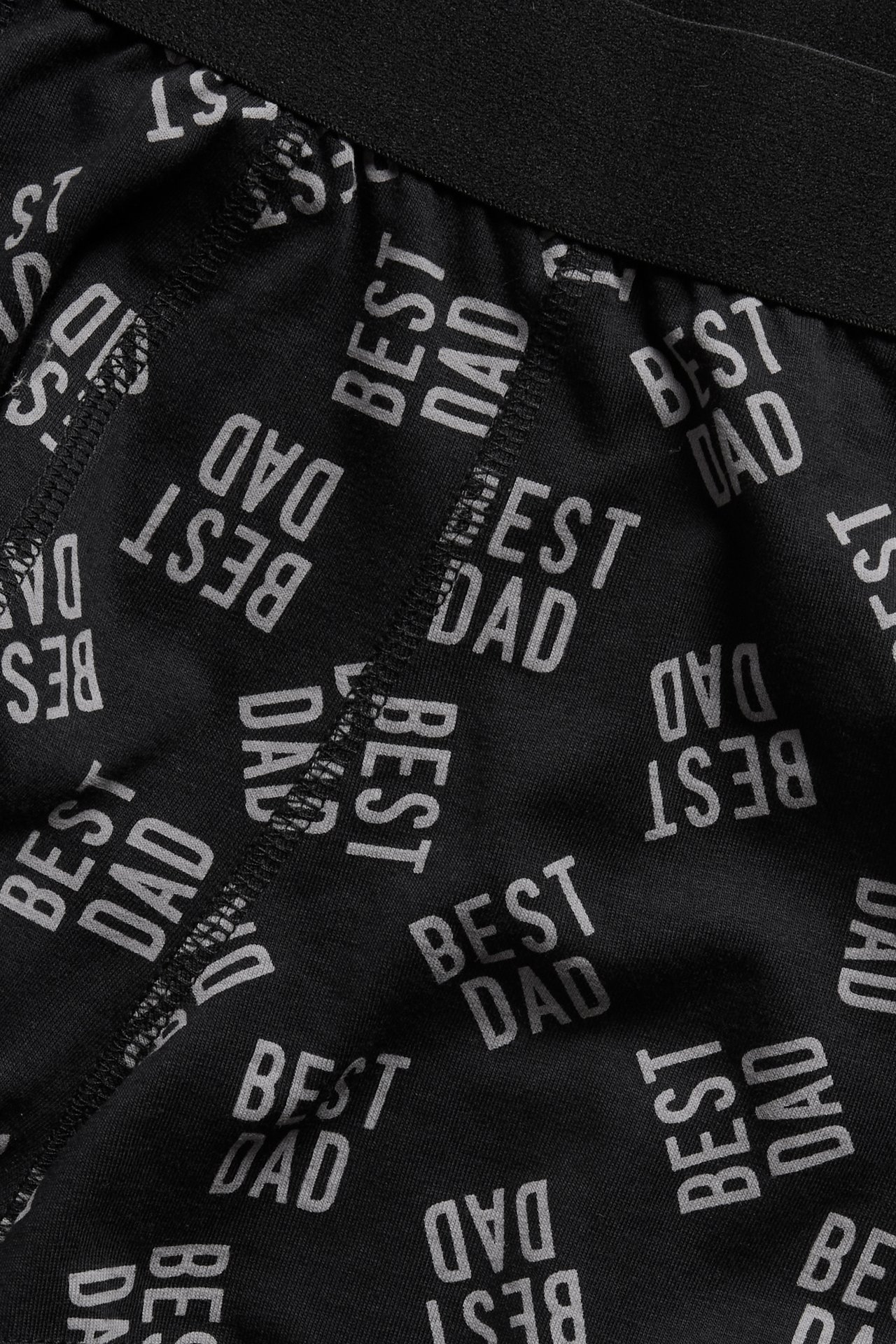 Lähikuva mustista miesten boksereista valkoisella 'BEST DAD' -printillä ja mustalla vyötärönauhalla.