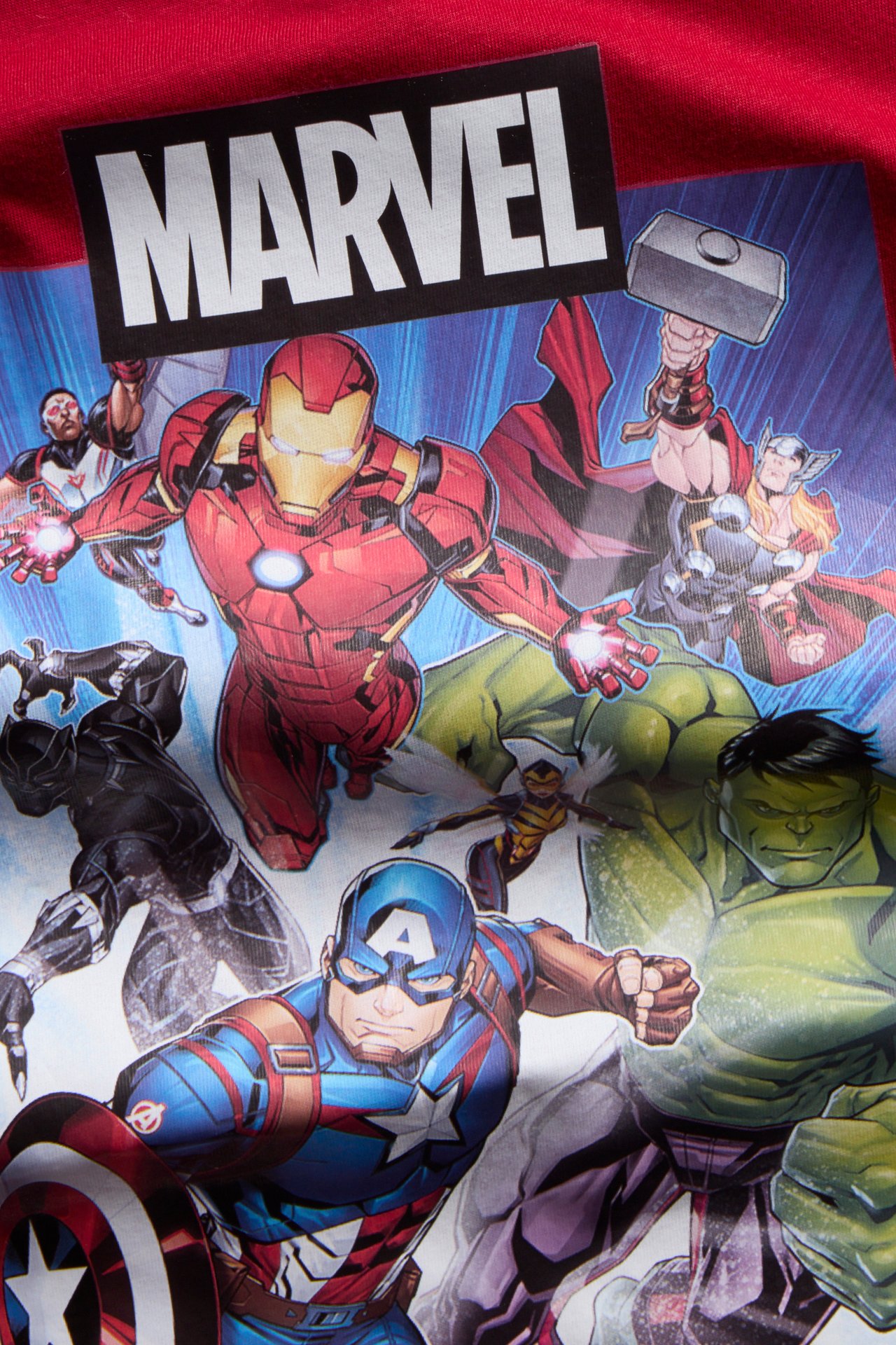 Zbliżenie czerwonego ubrania z kolorowym nadrukiem superbohaterów Marvel Comics.