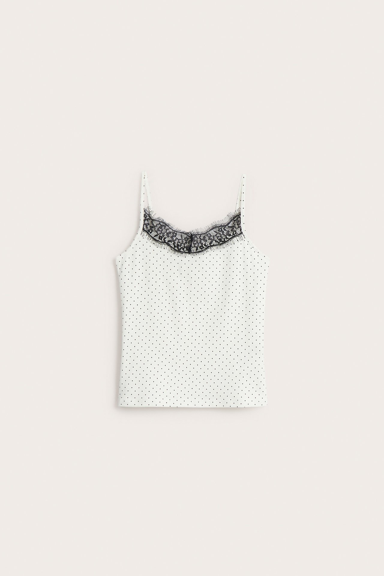 Widok z przodu na biały, wzorzysty top na ramiączkach z czarną koronką.