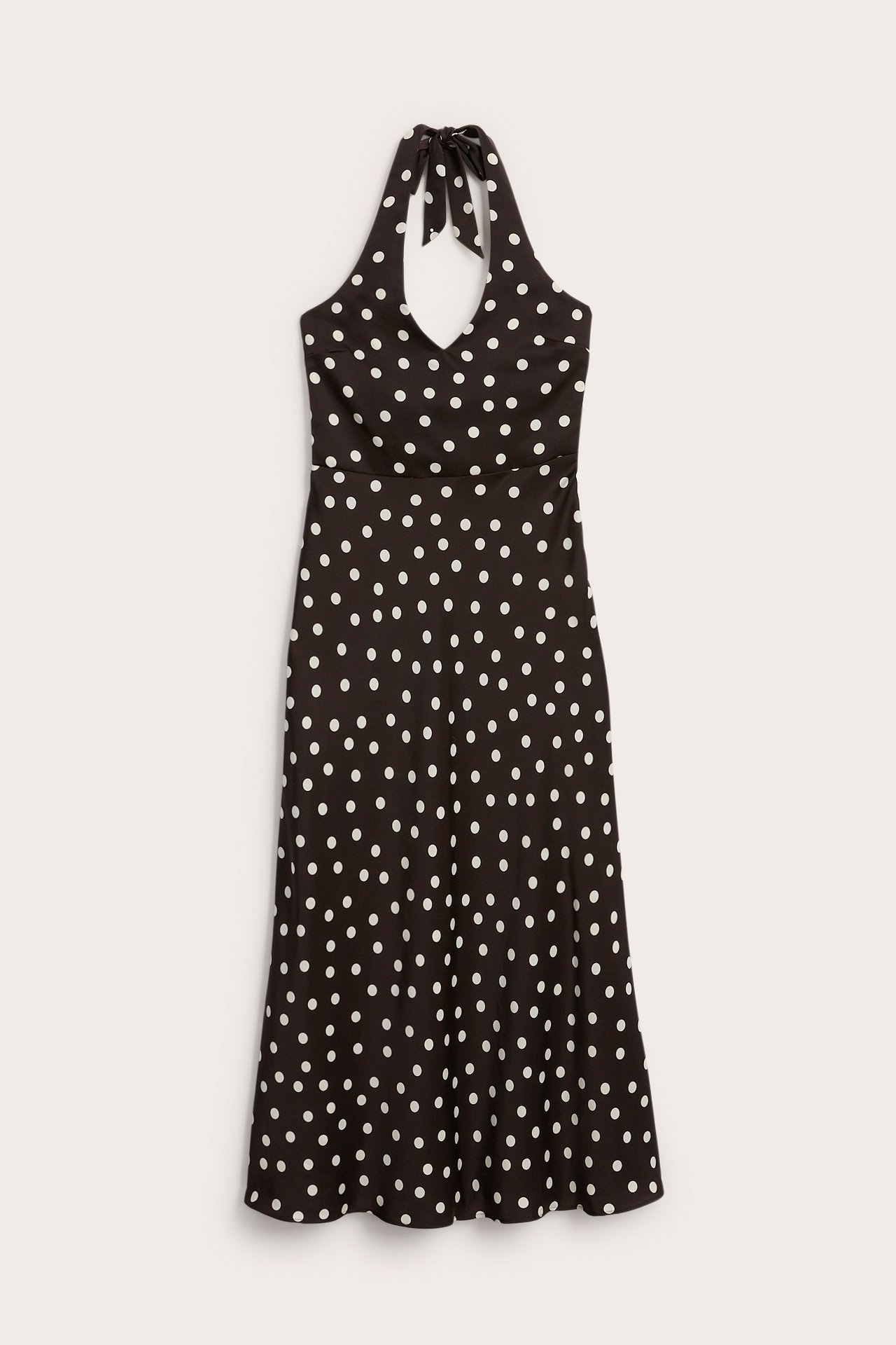 Edestä päin musta pilkullinen halterneck midimekko V-pääntiellä ja rusetilla.