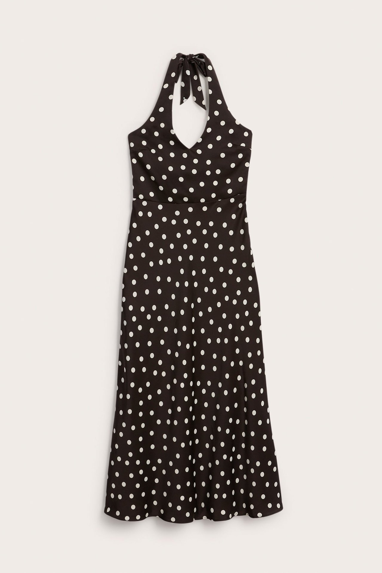 Edestä päin musta pilkullinen halterneck midimekko V-pääntiellä ja rusetilla.