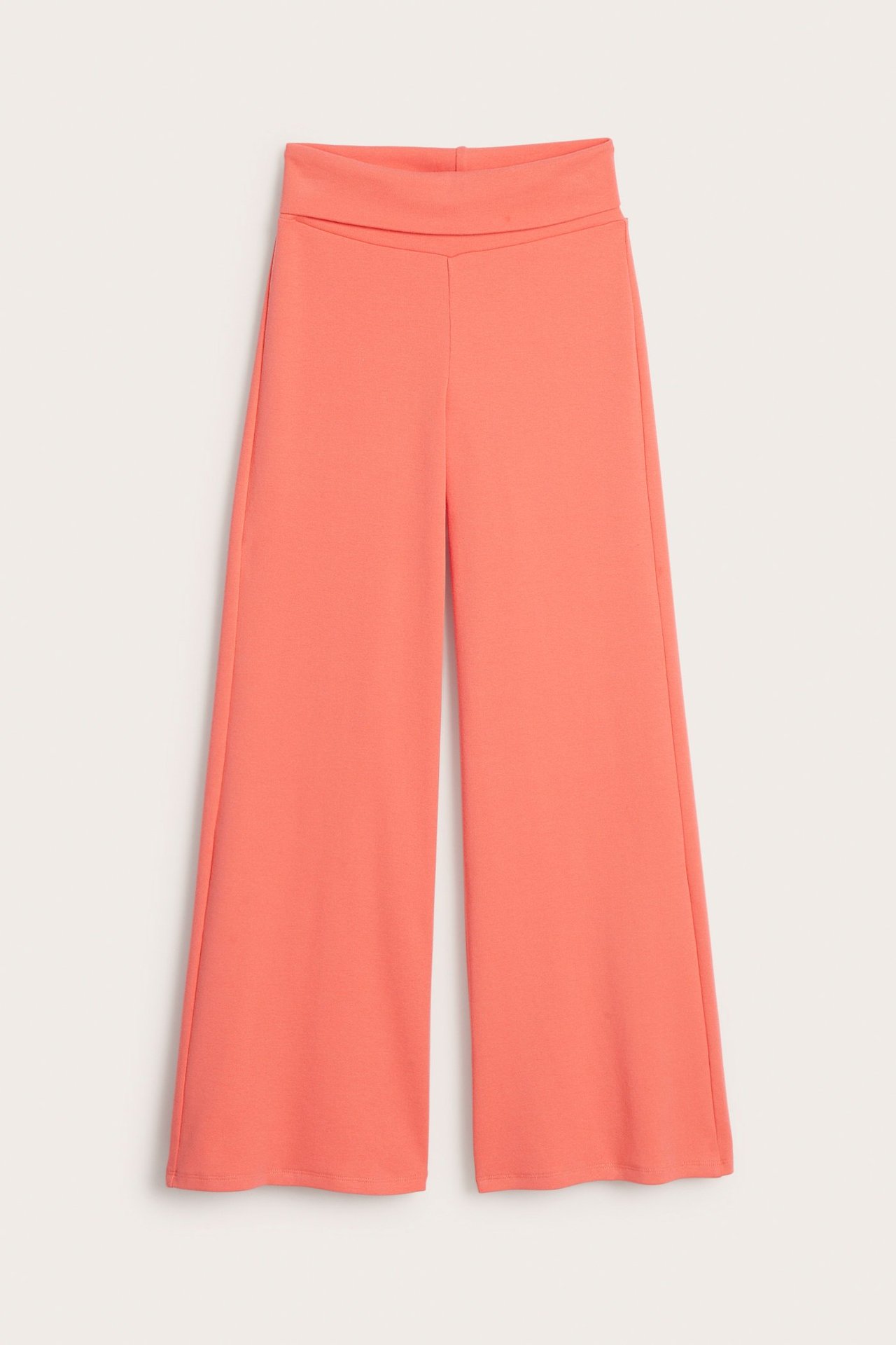 Framifrån, enfärgade vida orange utsvängda yogabyxor för barn med bred omlottmidja.