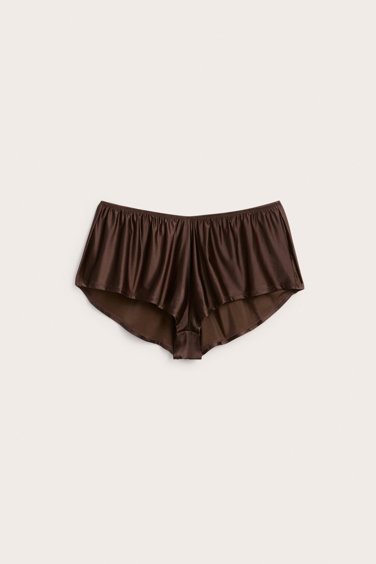 Framsida av mörkbruna löst sittande shorts i satin med resår i midjan.