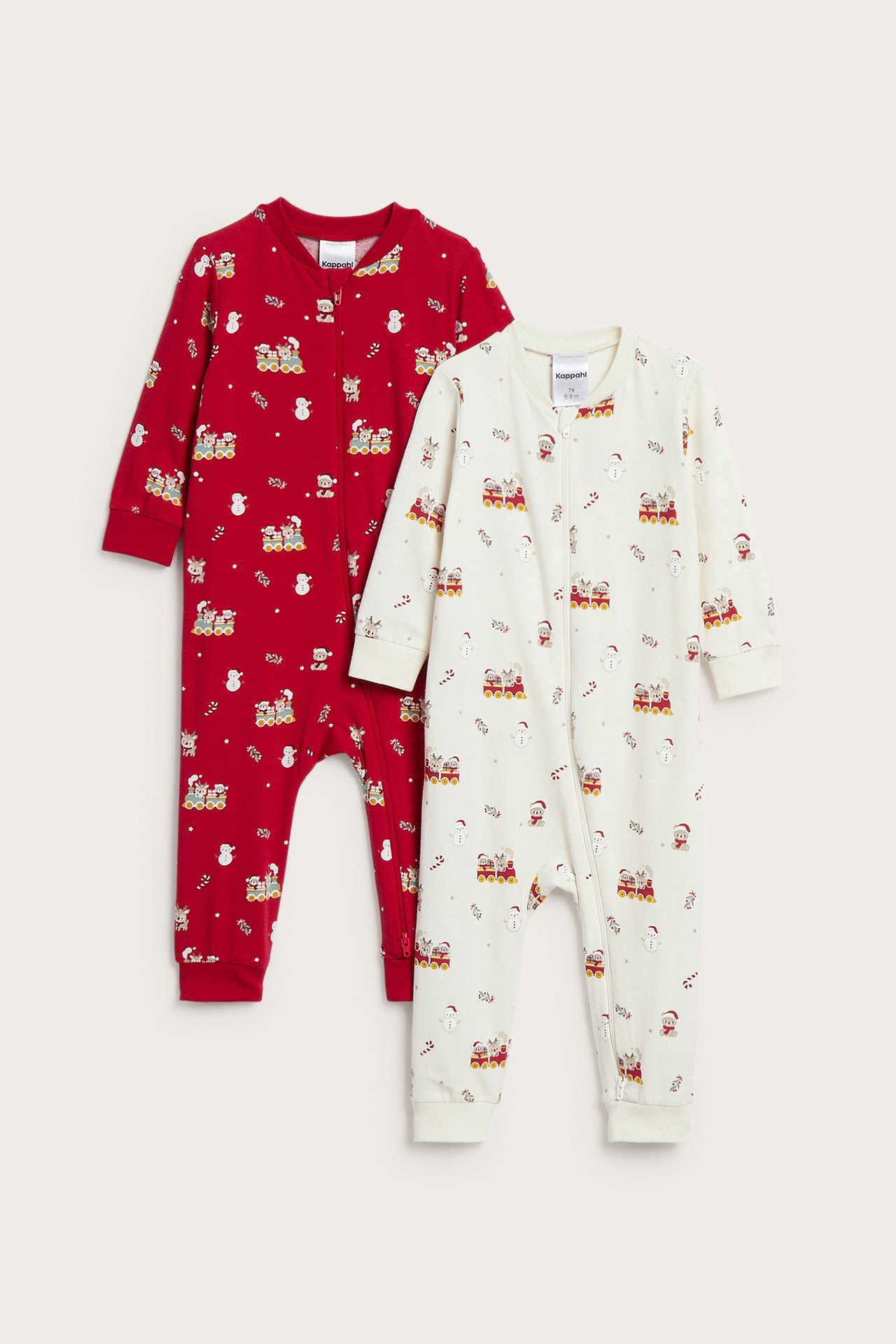 Front view av en krämfärgad och en röd babyromper, båda med jultryck och dragkedjor.