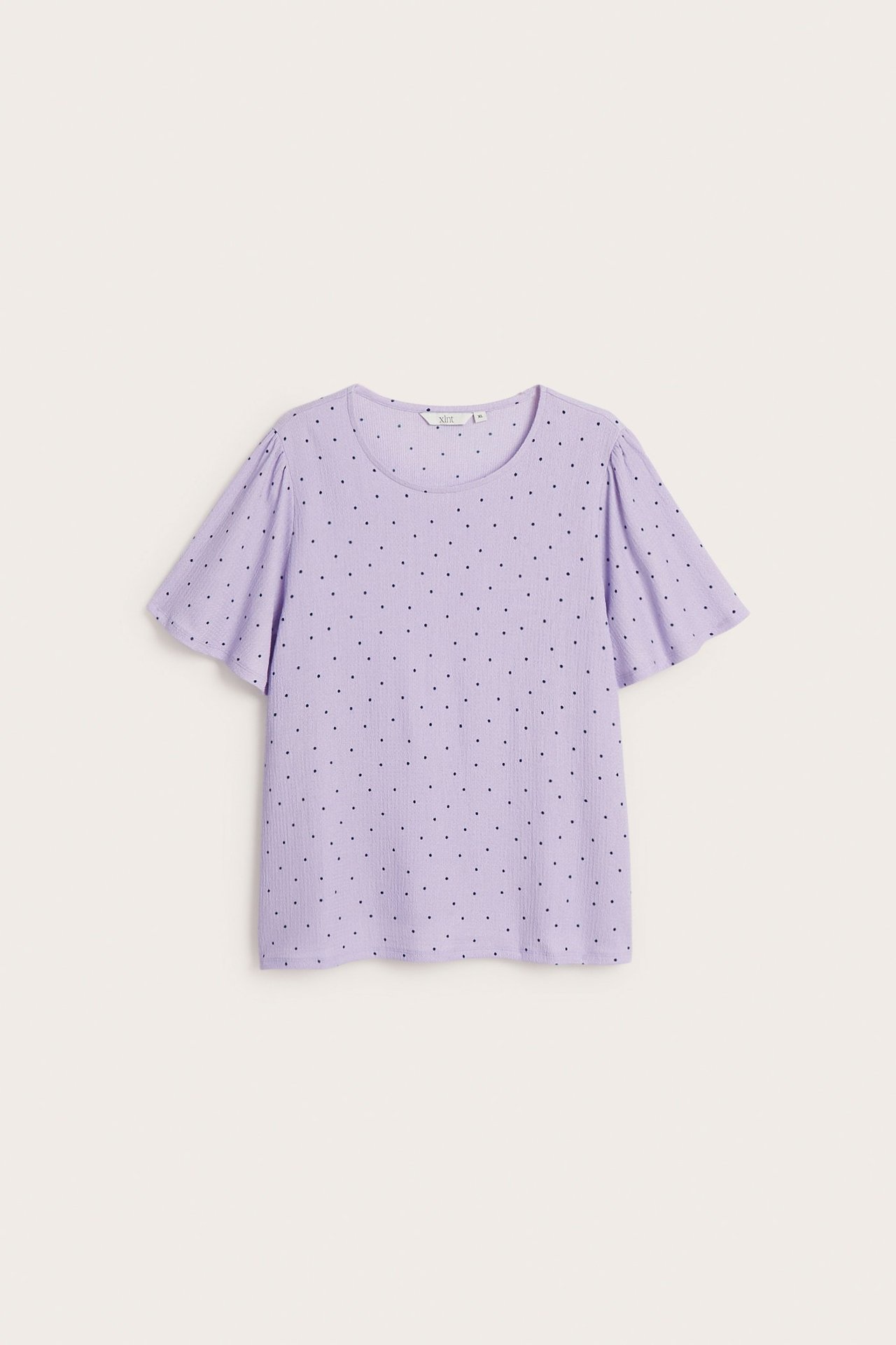 Framifrån: Ljuslila ribbad kortärmad topp med svarta prickar.