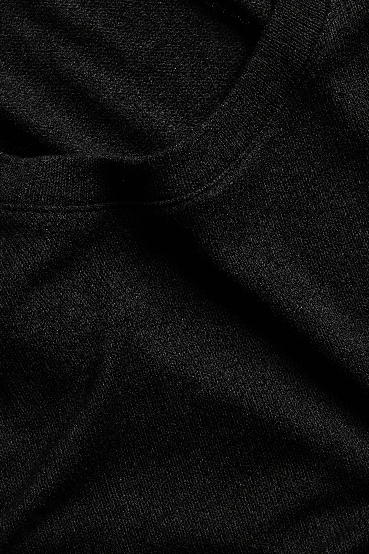 Lähikuva mustasta regular-t-paidasta, jossa pyöreä kaula-aukko, valmistettu viskoosisekoiteneuloksesta.