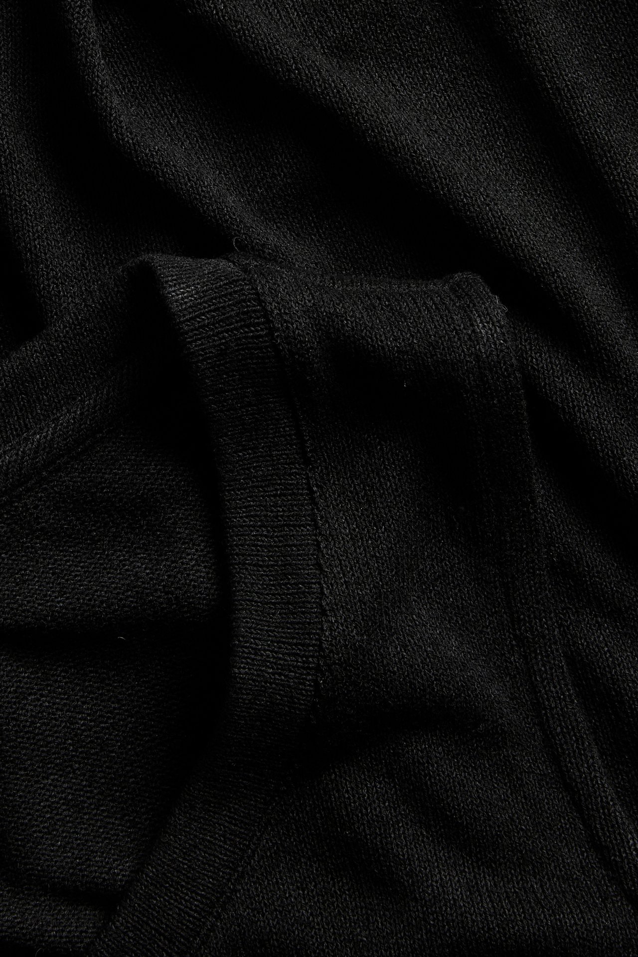 Lähikuva mustasta viskoosisekoitepaidasta, joka näyttää kankaan rakenteen ja siistin helman.
