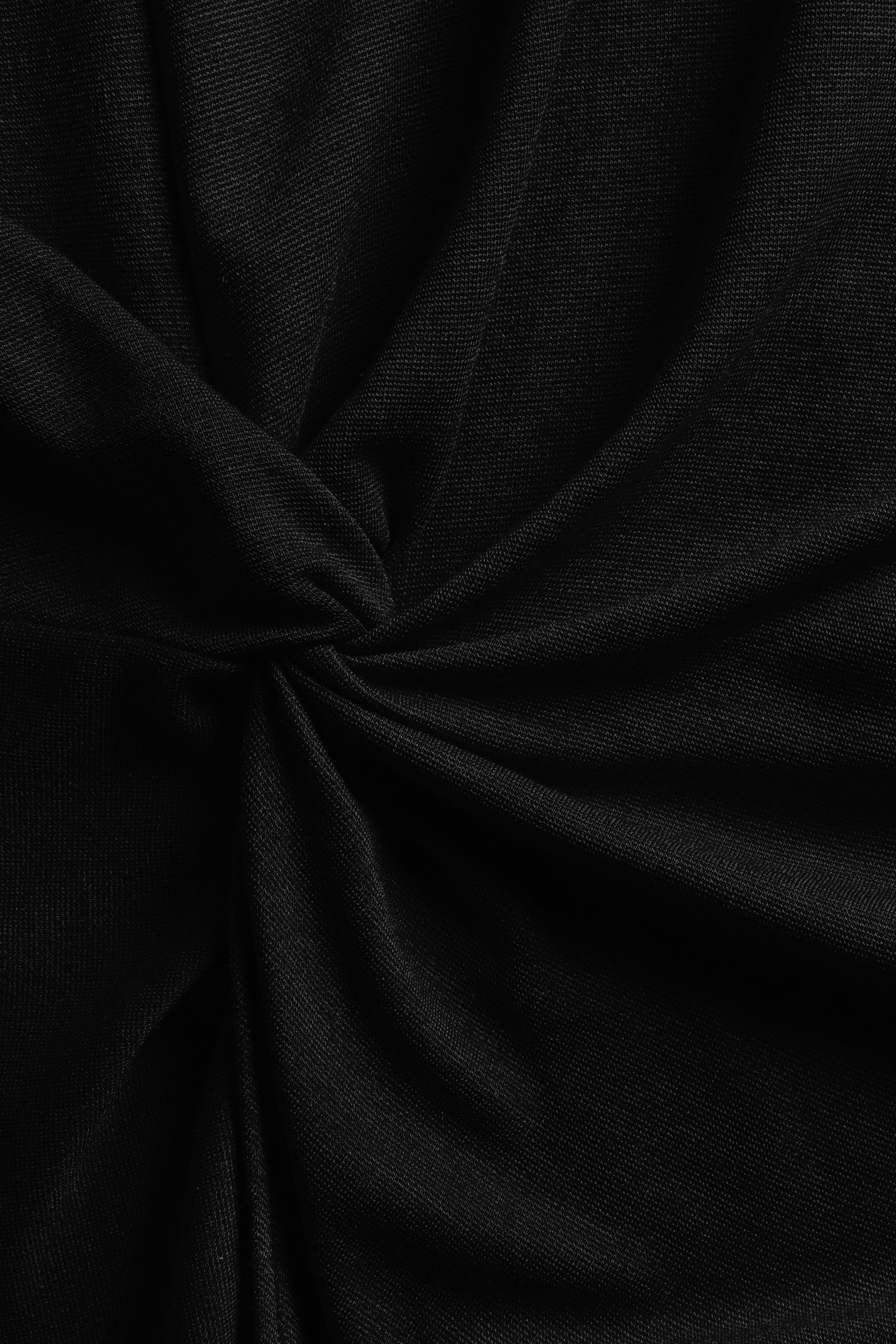 Zbliżenie czarnego materiału z widocznym detalem węzła.