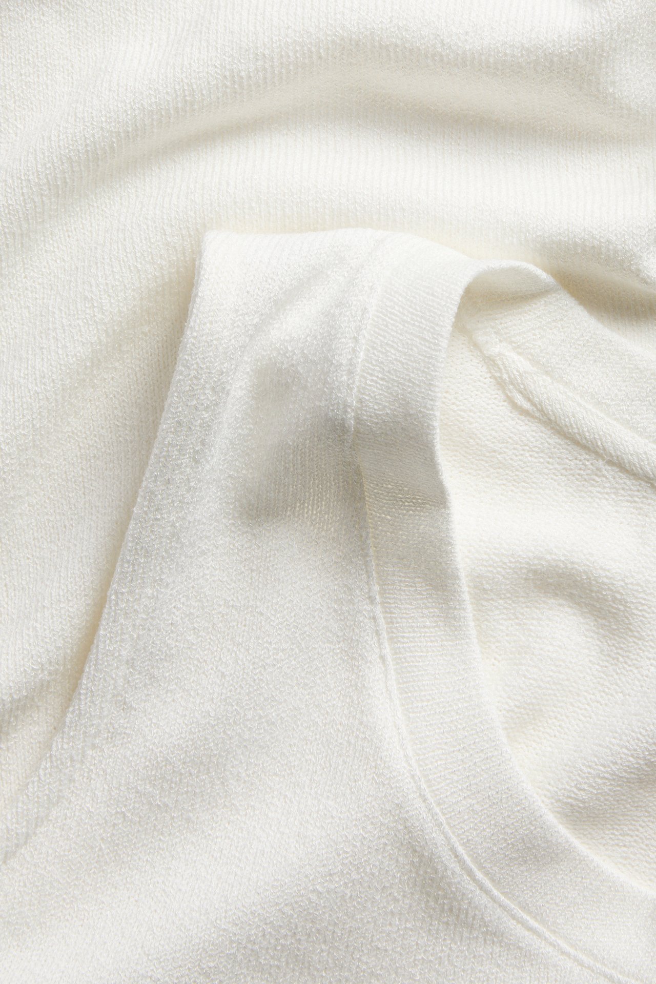 Lähikuva luonnonvalkoisesta viskoosisekoitepaidasta, jossa näkyy pehmeä kangas ja pääntie.