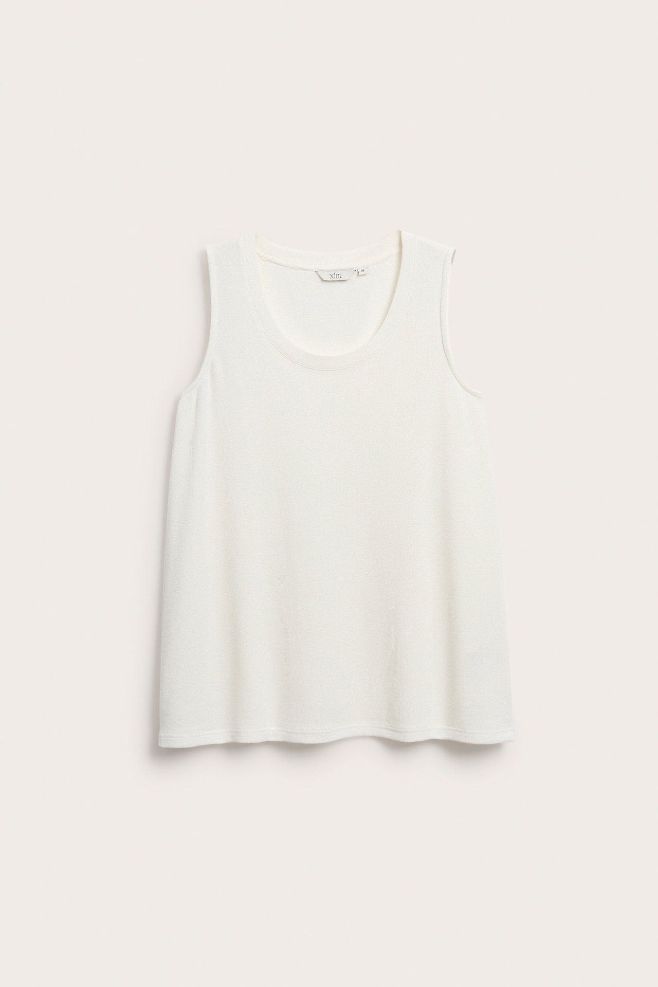 Edestäpäin, luonnonvalkoinen, yksivärinen, pitkä viskoosimix-toppi pyöreällä pääntiellä.