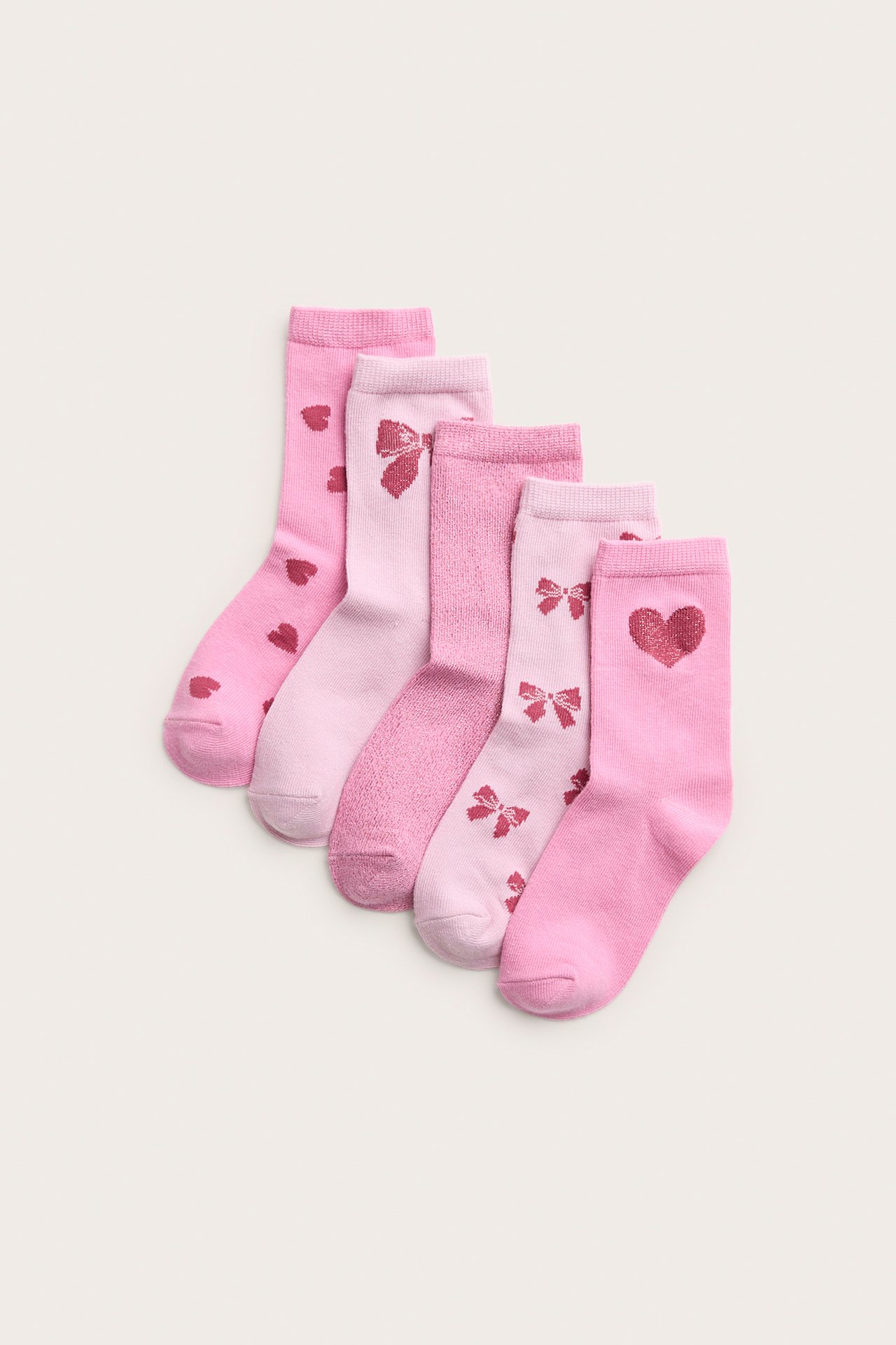 Uppifrån sett, sex par rosa strumpor med olika hjärt- och rosettmönster.