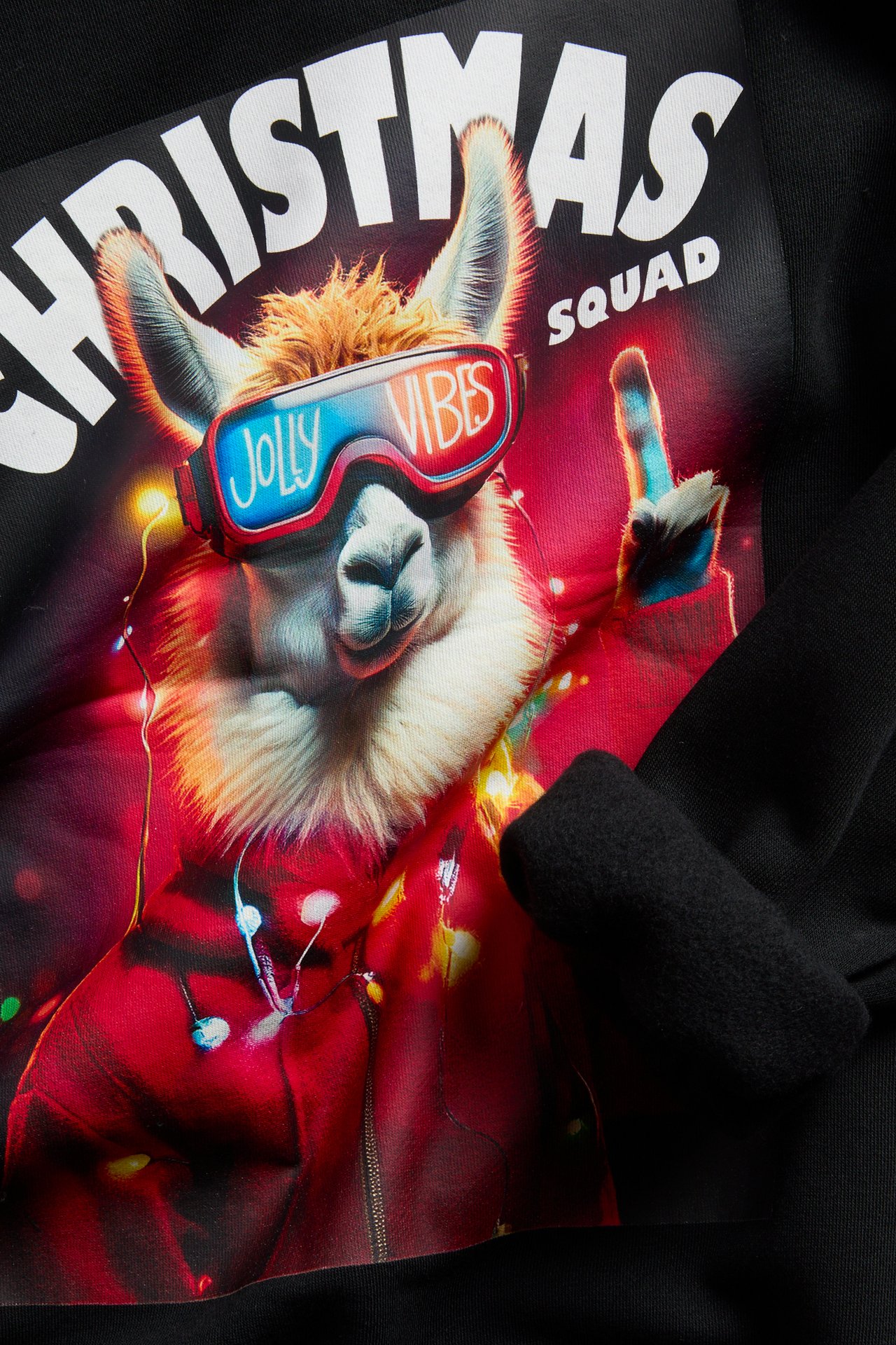 Widok z bliska z przodu czarnej bluzy z kolorowym nadrukiem świątecznej lamy i napisem "Christmas Squad".