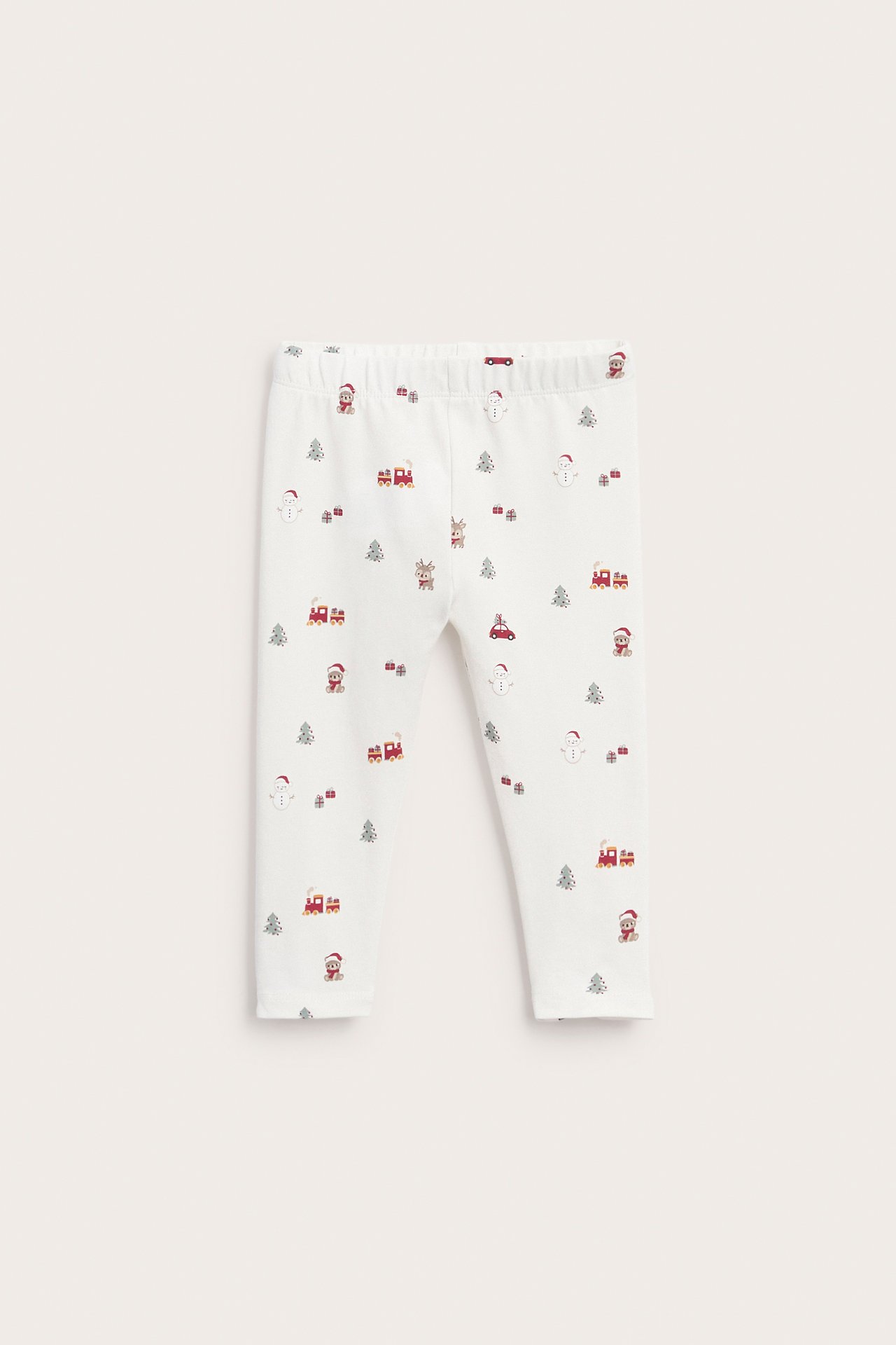 Framifrån vita babybyxor med festligt julmönster inklusive snögubbar, renar och tåg.