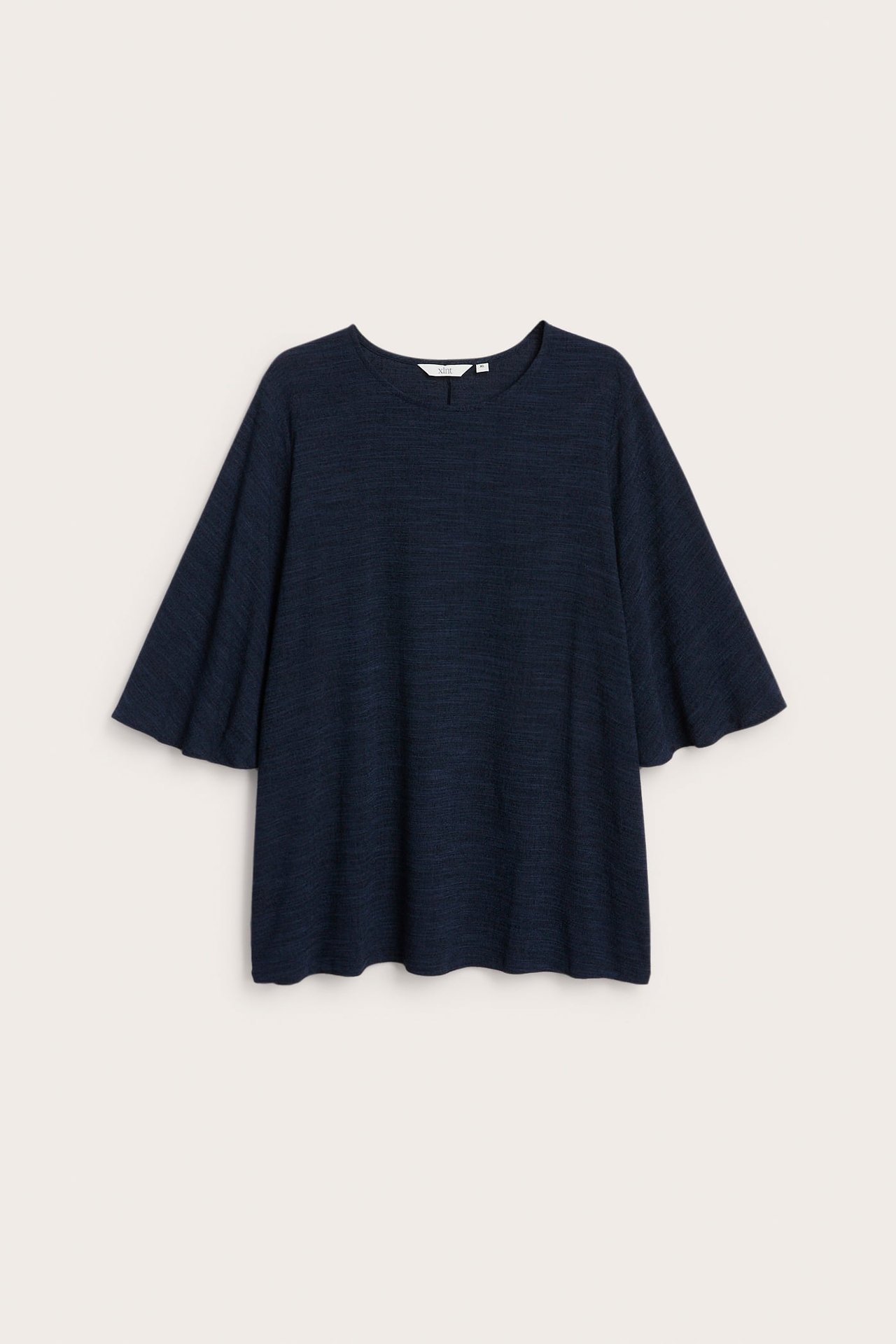Frontbilde av en mørkeblå, løs jerseytop med vide cape-ermer og rund hals.