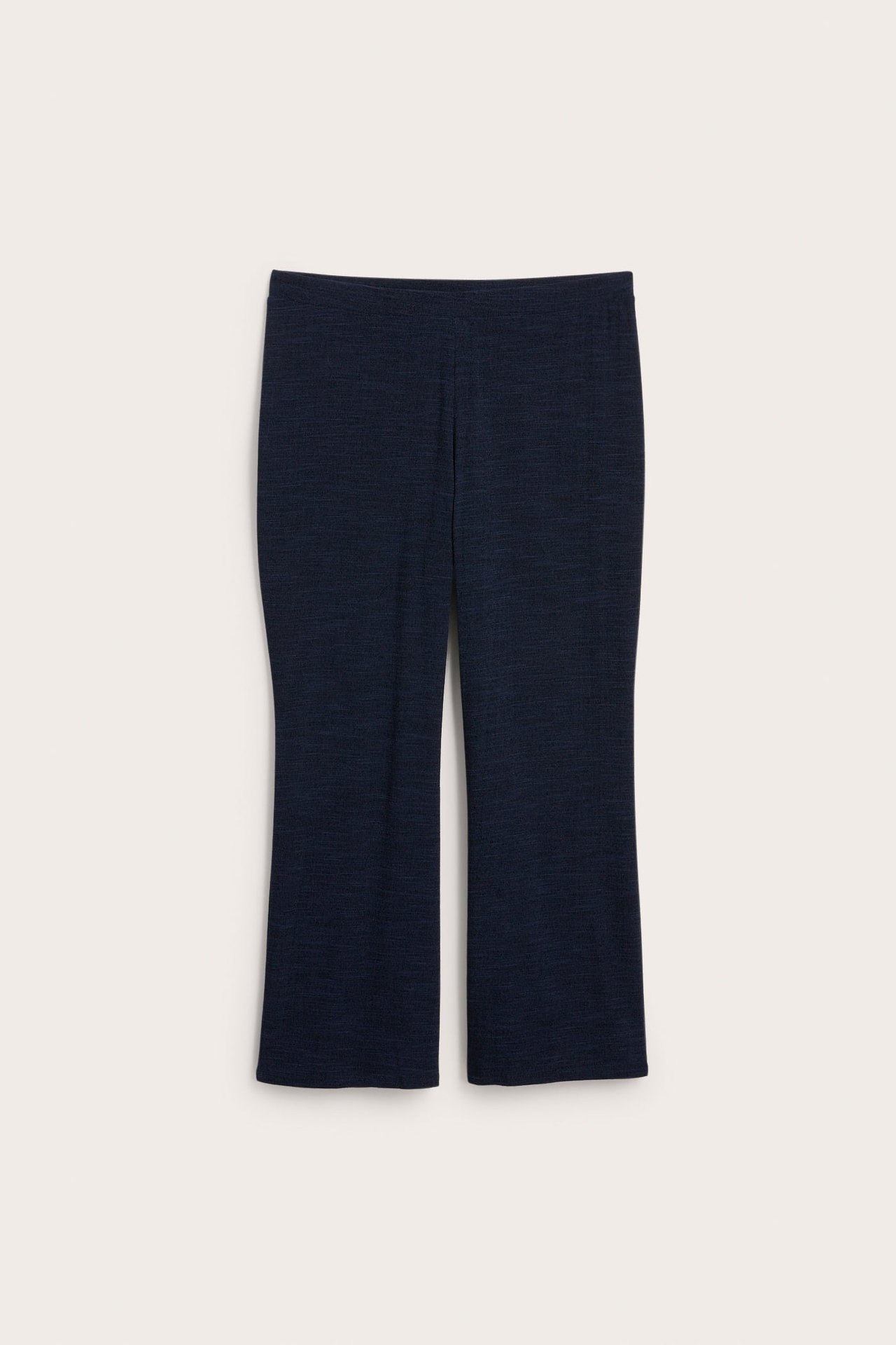 Widok z przodu granatowych, gładkich spodni dżersejowych bootcut.