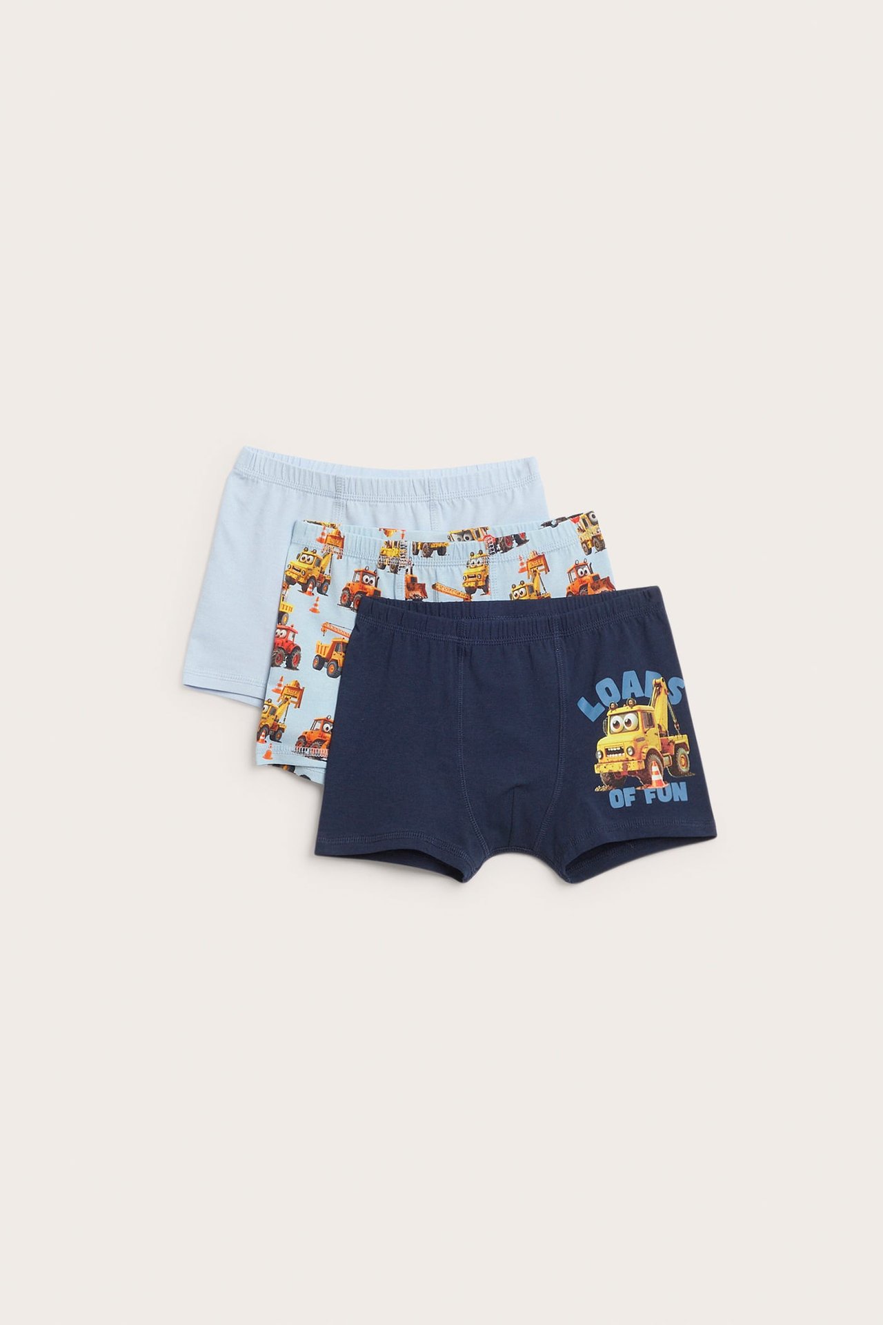 Framifrån, pojkboxershorts: mörkblå med lastbilstryck, samt två ljusblå par.