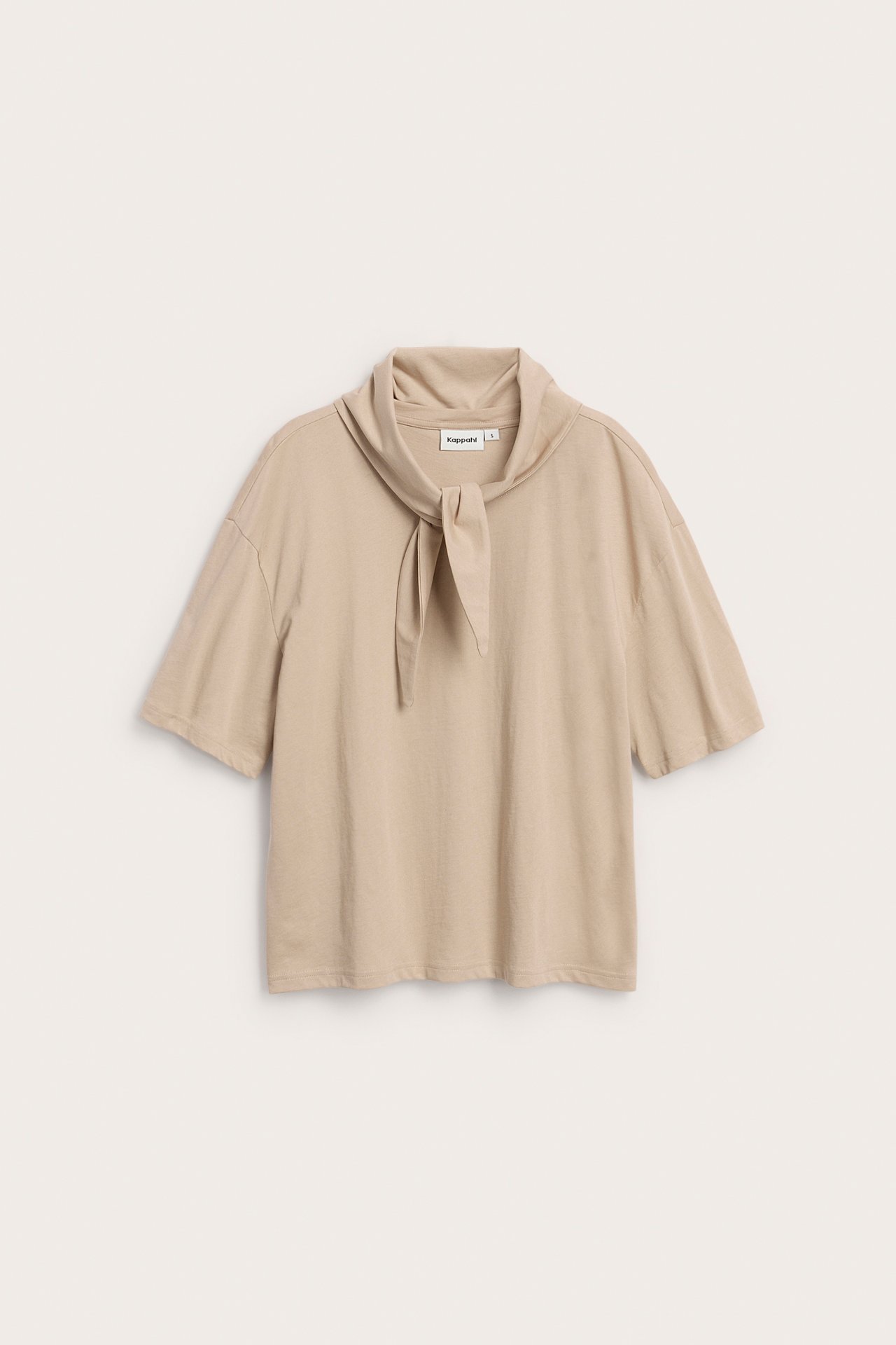 Frontvy av en beige kortärmad T-shirt i bomull med en matchande sjal knuten i halsen.