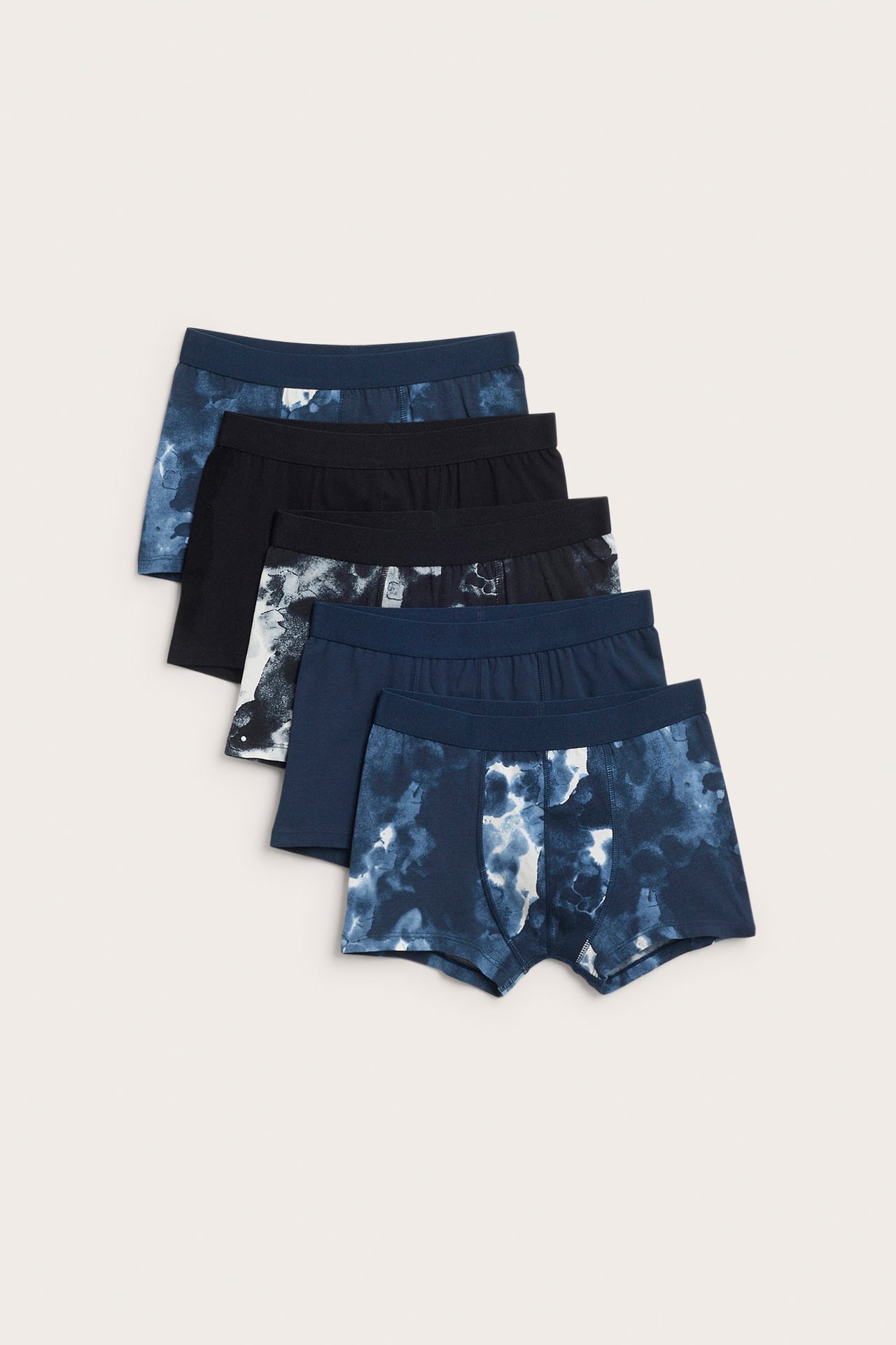 Frontbilde av en mørkeblå tie-dye bokser og fire andre blå og svarte herrebokser.