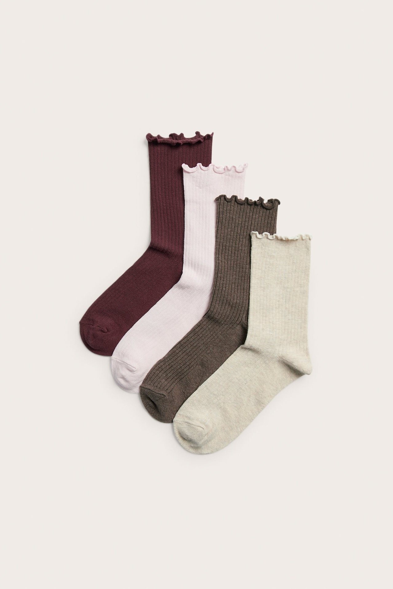 Fyra par ribbade strumpor med volangkanter i vinrött, ljusrosa, mörkbrunt och ljusbeige.