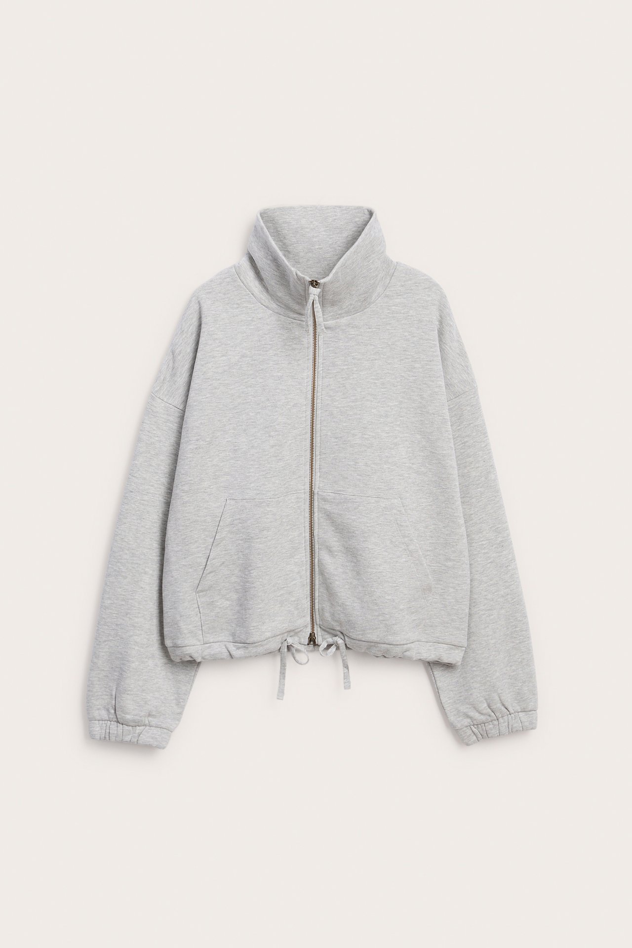 Framsida av gråmelerad kort sweatshirt med dragkedja, hög krage och dragsko.