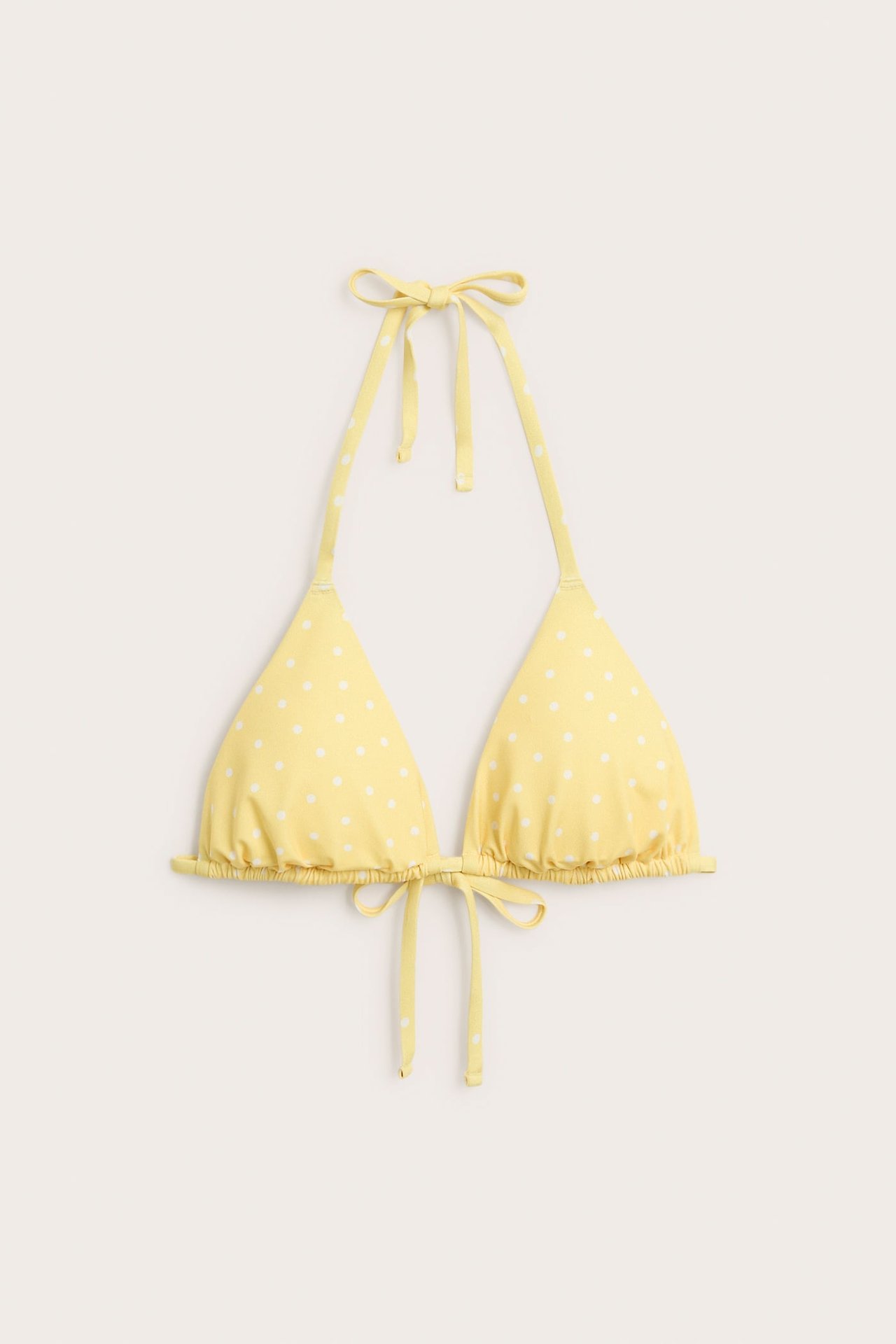 Widok z przodu żółtego biustonosza bikini w kropki z wiązaniami na szyi i plecach.