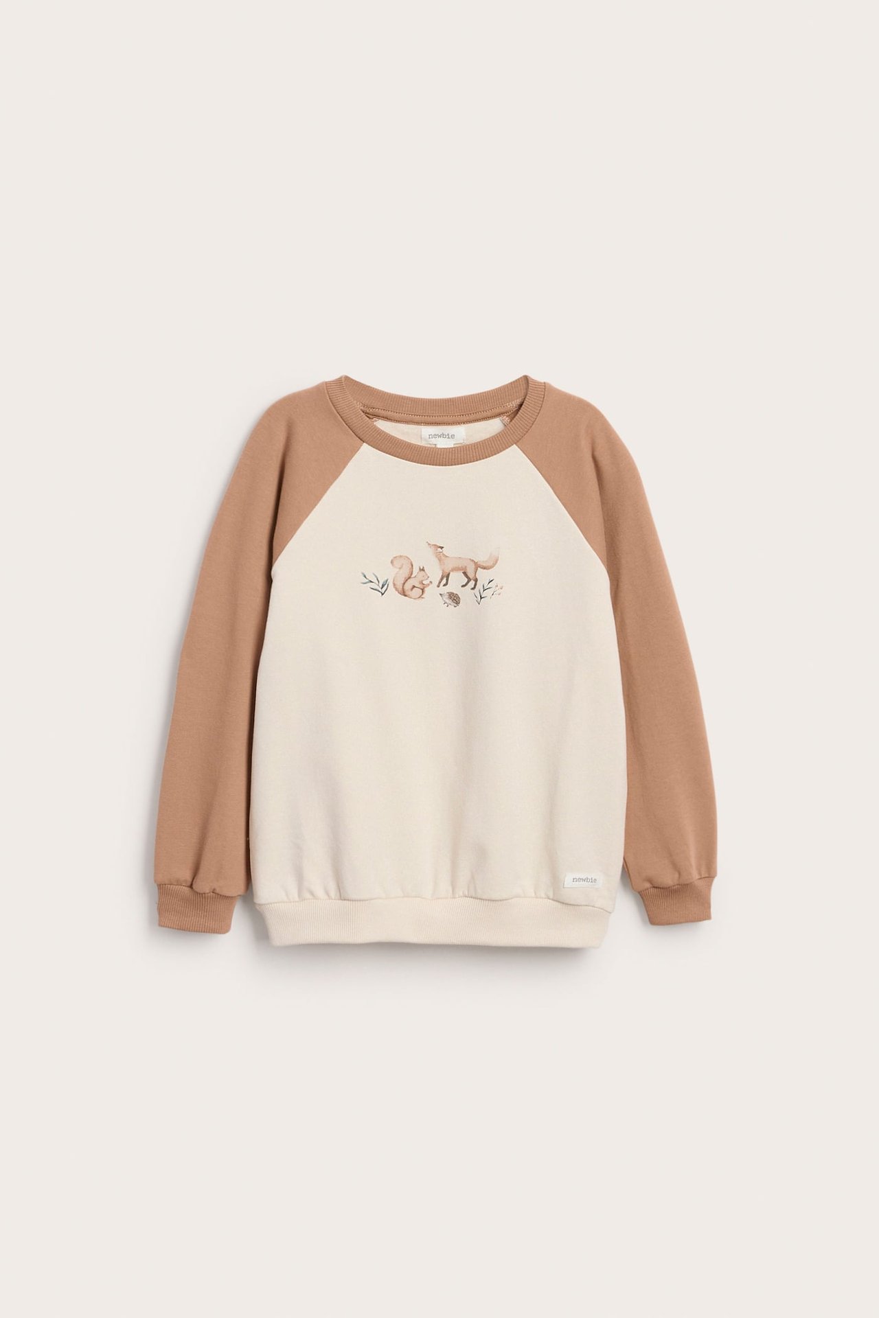Forfra, barnegenser i beige med brune raglanermer og dyreprint.