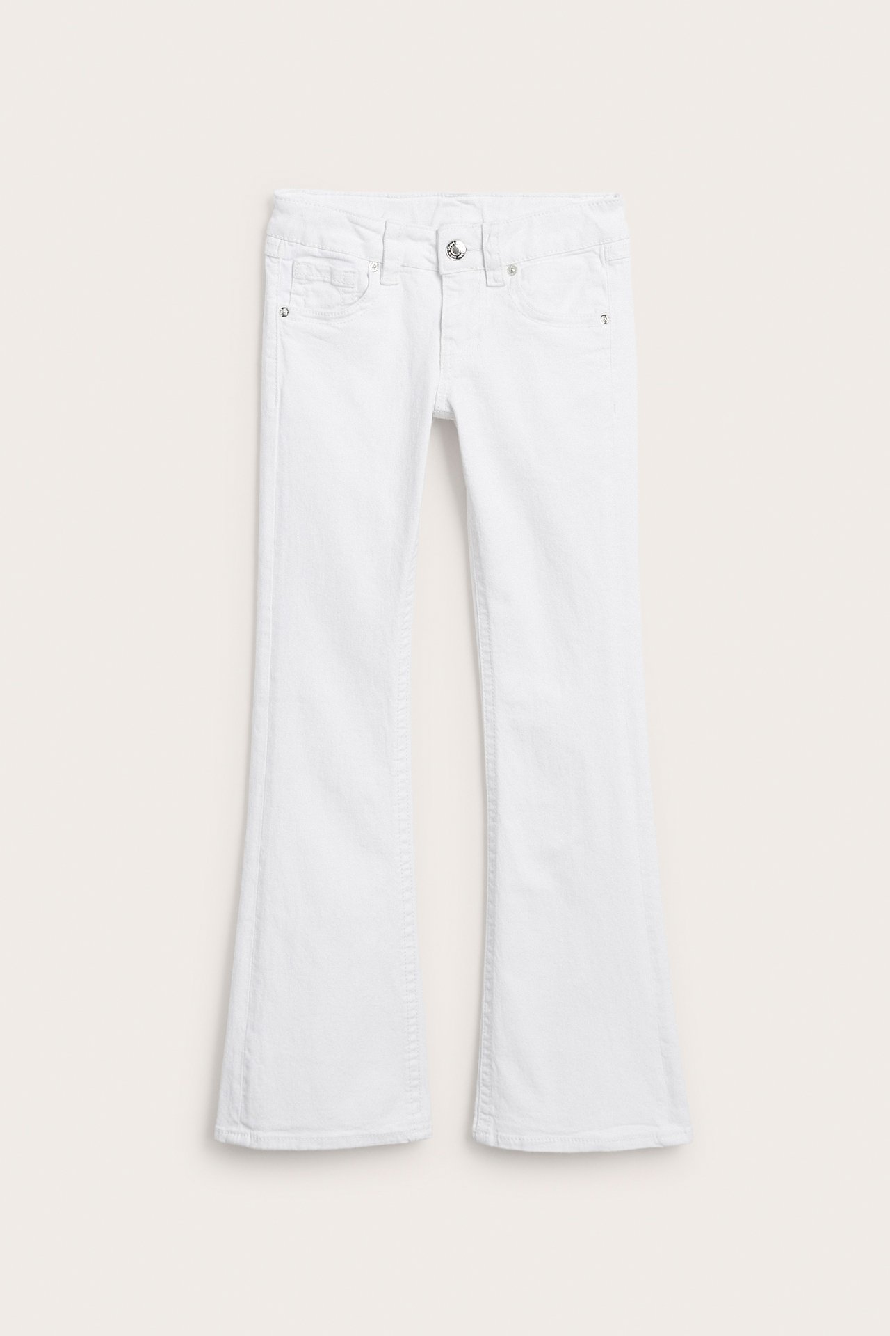 Framifrån, vita utsvängda jeans med knäppning och dragkedja.