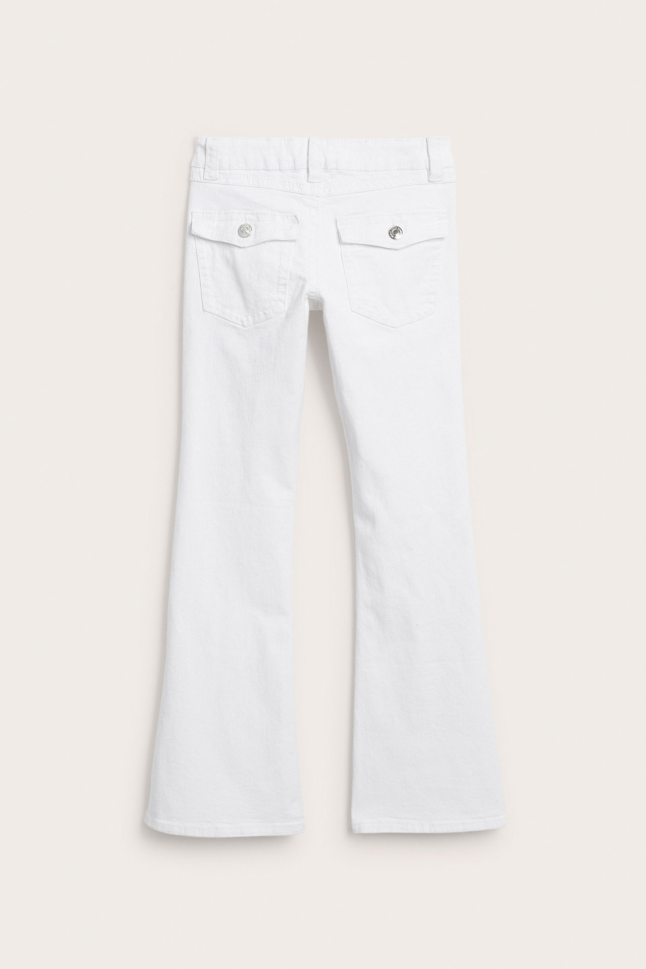 Baksida av vita utsvängda jeans med två bakfickor med knappflik.