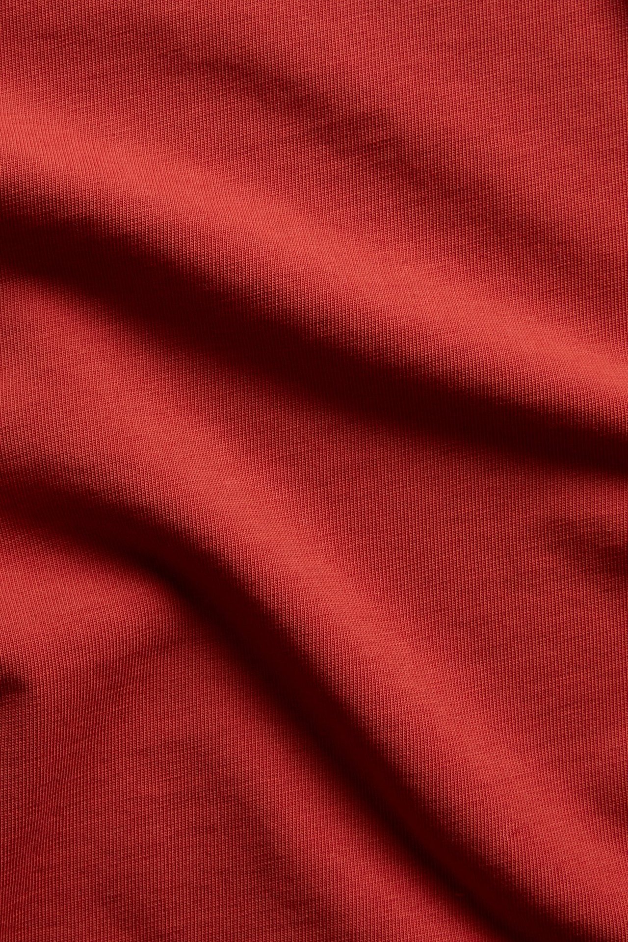 Närbild av ett draperat rött ribbat stickat tyg.
