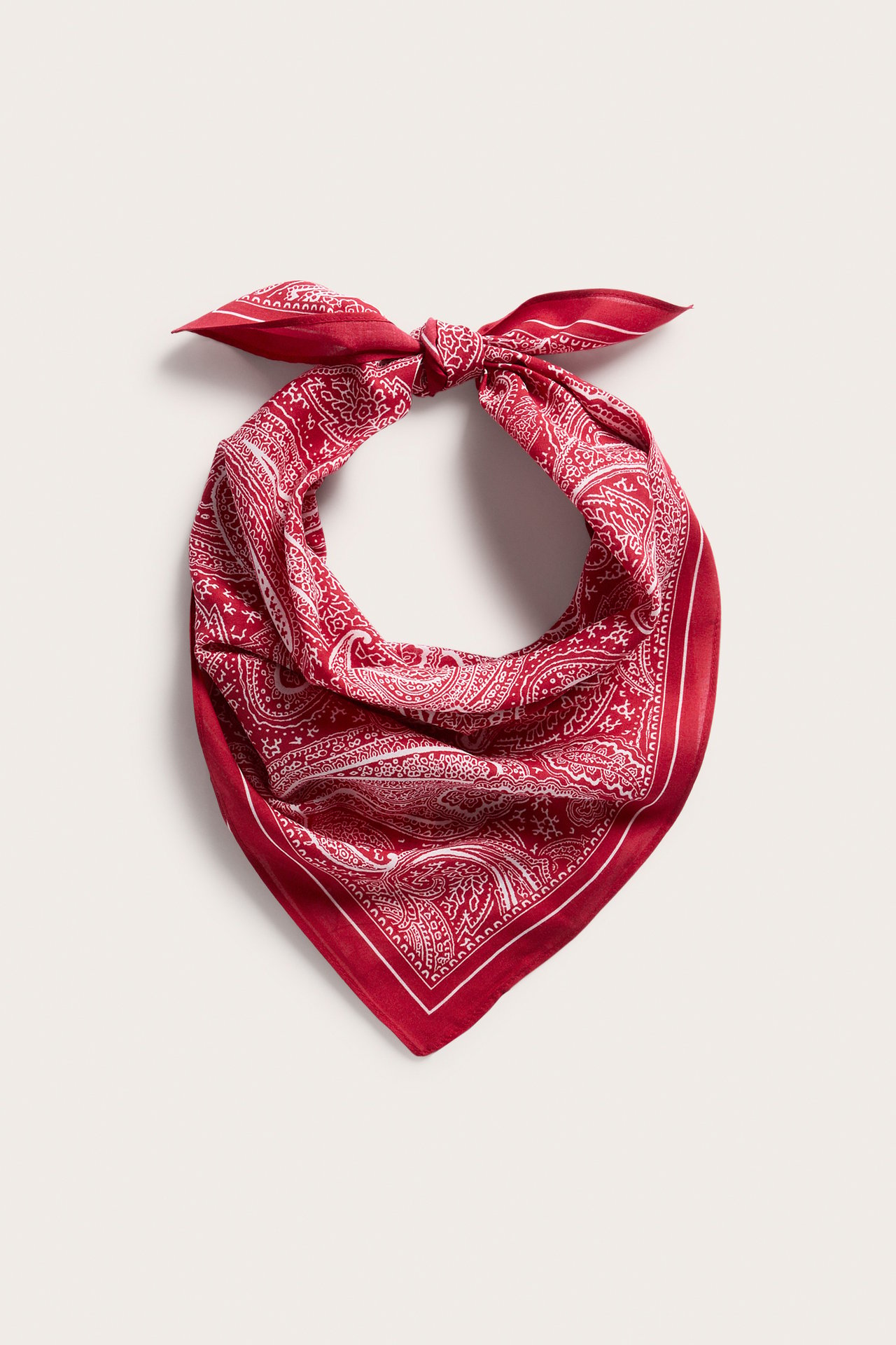 Edestä, punainen bandana valkoisella paisley-kuviolla, sidottu yläosasta.