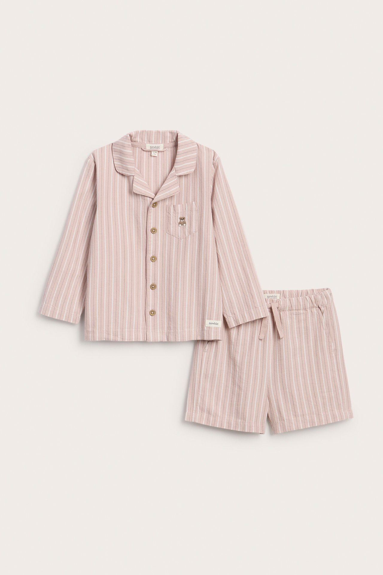 Framifrån: Rosa randig pyjamasskjorta med nalleficka och matchande shorts för barn.
