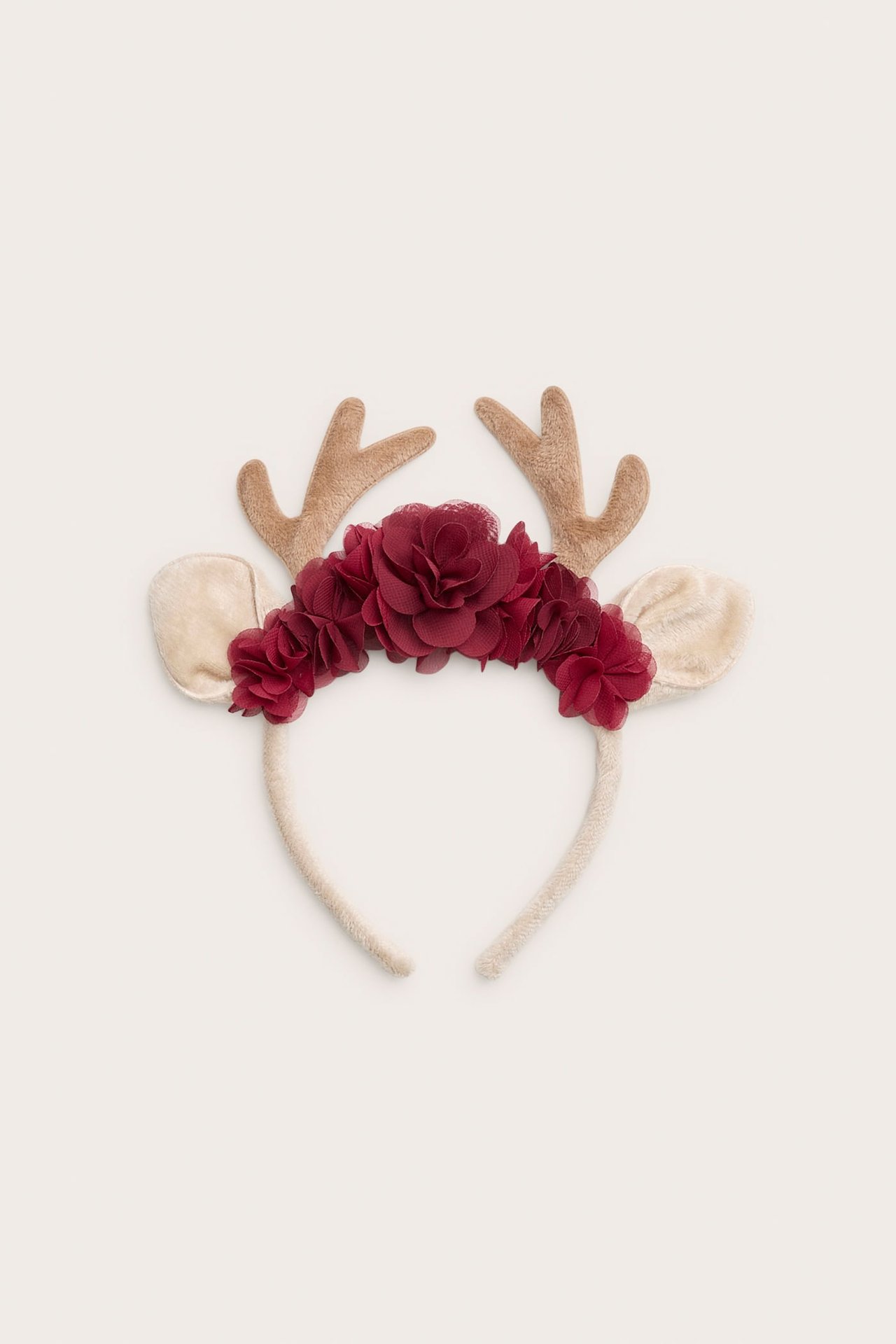 Från framsidan: ett ren-hårband med bruna horn, beiga öron och ett vinrött blomkluster.