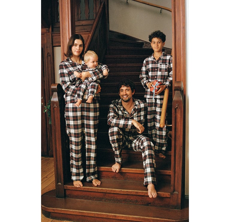 En kvinna, en man, en kille och en bebis i matchande rutiga pyjamasar.