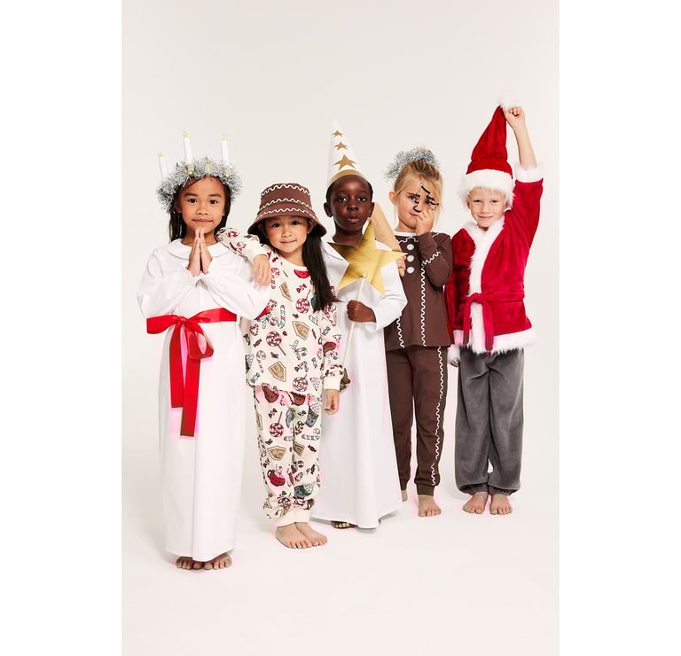 Pięcioro dzieci w różnych strojach Świętego Mikołaja i strojach Łucji.