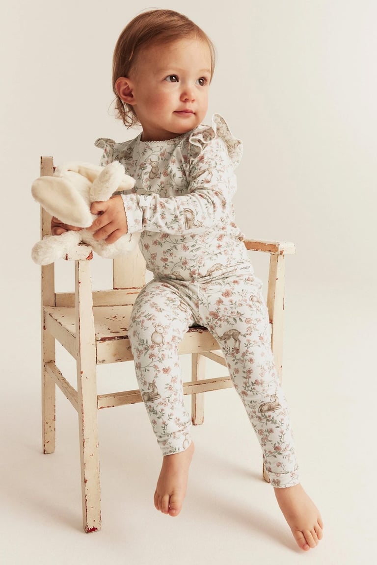 Baby på en stol i matchende sett fra Newbie.
