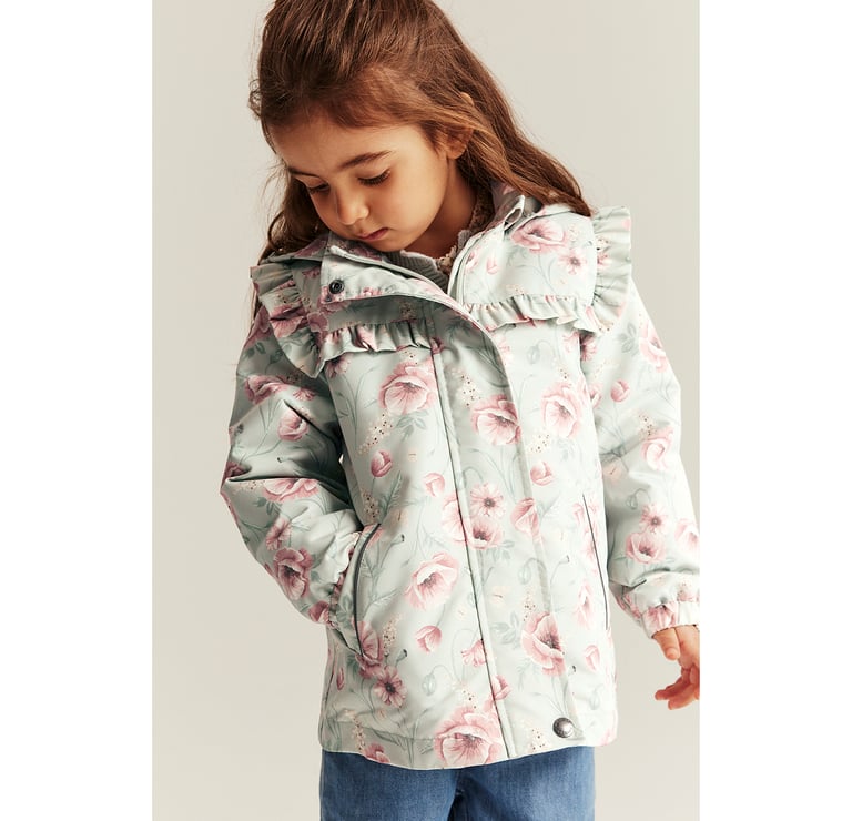 Jente som ser ned i bakken er kledd i en blomstrete jakke fra Newbie.